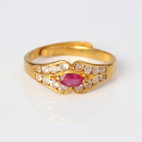 RING. 23k guld (995/1000) med färglösa stenar och en syntetisk rubin, totalvikt ca 4,2 gram. på auktion hos Skånes Auktionsverk