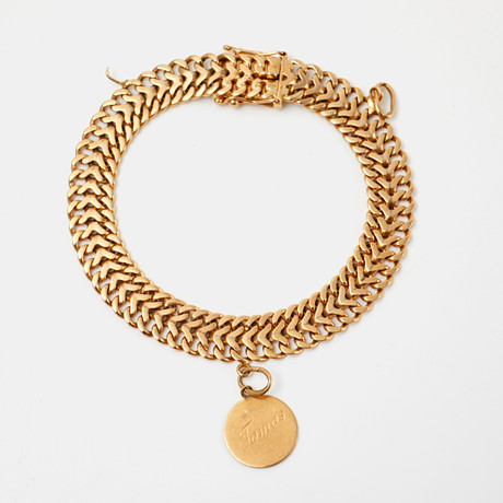 ARMBAND, 18 k guld, fiskbenslänk, med en berlock, Ge-Kå-Smyckek G Kaplan, Stockholm, 1964. på auktion hos Stockholms Auktionsverk Sickla
