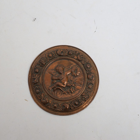 DEKORATION, 1800-1900-tal, förkoppad metall, med rik reliefdekor av bland annat kerub. på auktion hos Falun Auktionsbyrå