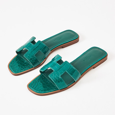 HERMÈS, "Oran sandals", smaragdgröna, patenterat krokodilskinn, storlek 38 1/2. på auktion hos Stockholms Auktionsverk Magasin 5