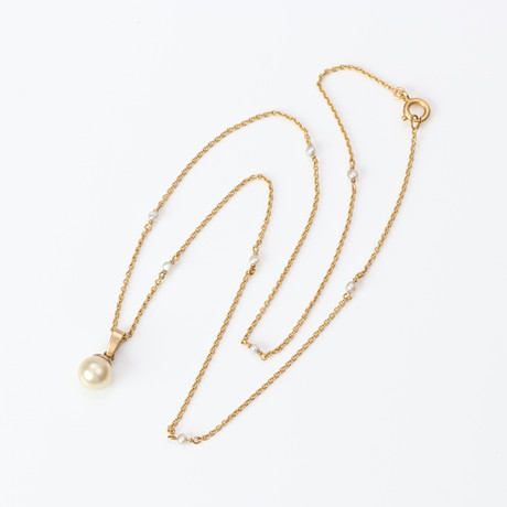 HALSBAND. 18k guld med fröpärlor, hänge i förgyllt silver med pärlimitation, vikt exkl. hänge ca 2,8 gram. på auktion hos Skånes Auktionsverk