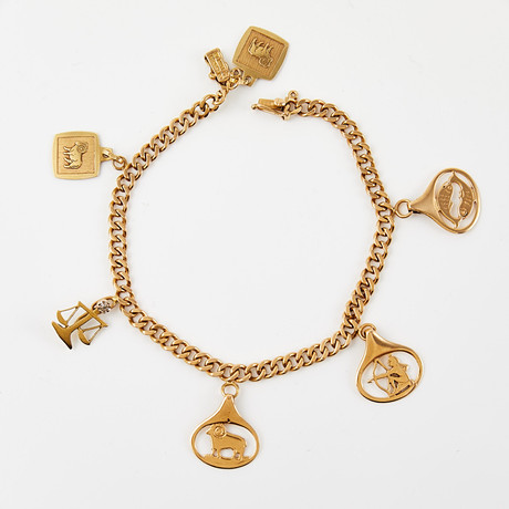 ARMBAND, 18 k guld, pansarlänk, behängd med 5 berlocker med olika stjärntecken, vågen med dekor av åttkantslip på auktion hos Stockholms Auktionsverk Sickla