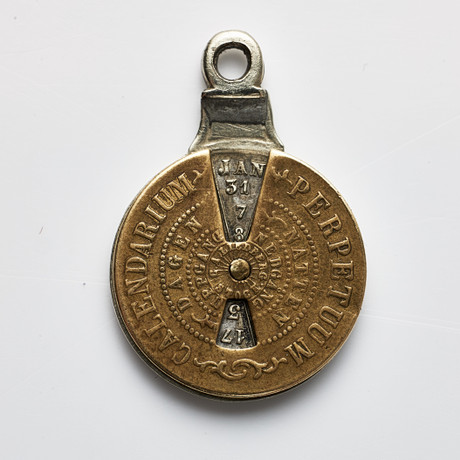 EVIGHETSKALENDER, "Calendarium Perpetuum", i form av mynt, vitmetall & mässing, sannolikt 1800-tal. på auktion hos Stockholms Auktionsverk Magasin 5