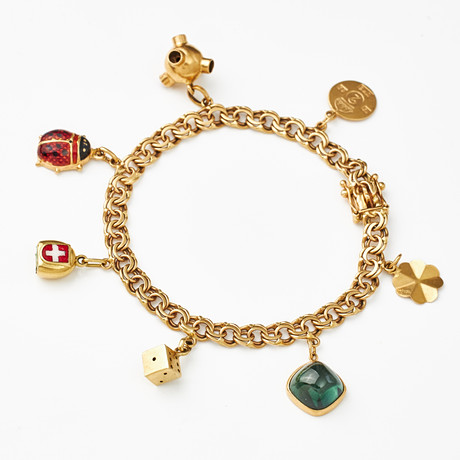 ARMBAND, 18 k guld, Bismarck, 7 berlcoker bl a föreställande nyckelpiga med emaljdekor, satellit, fyrklöver, t på auktion hos Stockholms Auktionsverk Magasin 5