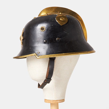 BRANDHJÄLM. Stockholms Brandkår, 18/1900, lackerad metall mässing. på auktion hos Stockholms Auktionsverk Sickla
