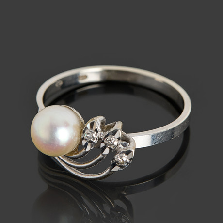 RING, 18k vitguld, genombruten dekor med en pärla samt 3 st enkelslipade diamanter. på auktion hos Crafoord Auktioner Stockholm