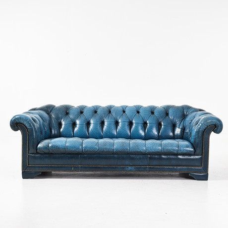 SOFFA. Chesterfield, 1900-talets andra hälft, blå skinnklädsel, pärlspikad dekor, lösa sittplymåer. på auktion hos Stockholms Auktionsverk Magasin 5