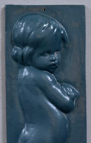 OIDENTIFIERAD KONSTNÄR. väggrelief, lackerat gjutjärn, stående putto. på auktion hos Halmstads Auktionskammare