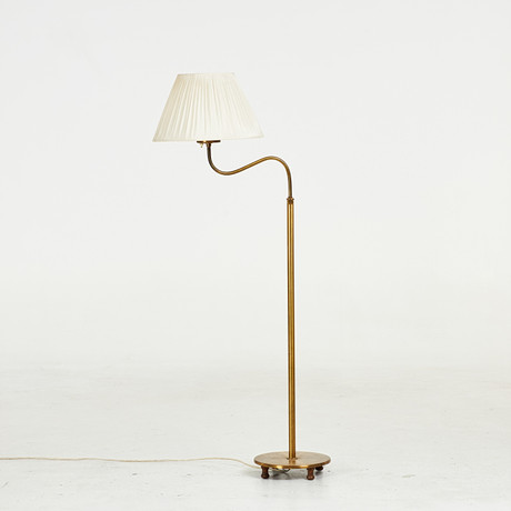 JOSEF FRANK. Golvlampa, modell G2568, "Lilla kamelen", Firma Svenskt Tenn, stomme av mässing, på fötter av bet på auktion hos Stockholms Auktionsverk Sickla