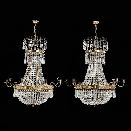 LJUSKRONOR, 1 par, 1900-talets slut, empirestil, för 9 ljus, stomme i mässing, behängd med prismor. på auktion hos Stockholms Auktionsverk Magasin 5
