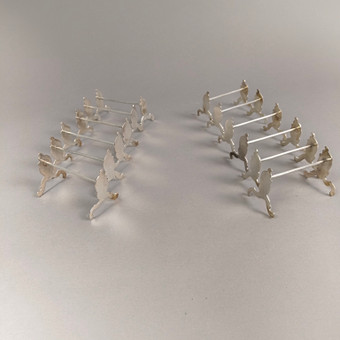 SET OF 12 SILVER KNIFE RESTS.
