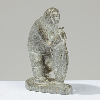 SIMON KRISTOFFERSEN (1933–1990). Unik skulptur udskåret af fedtsten forestillende grønlandsk jæger holdende stor fisk, signeret og dateret '89', Nuuk, Grønland.