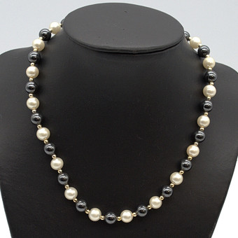 Collier de perles d'imitation, noir, blanc, séparateurs dorés, vers 1950, env. 41 cm.