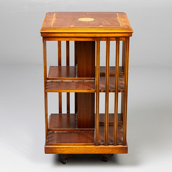 A YEW WOOD VENEER REVOLVING BOOK CASE.