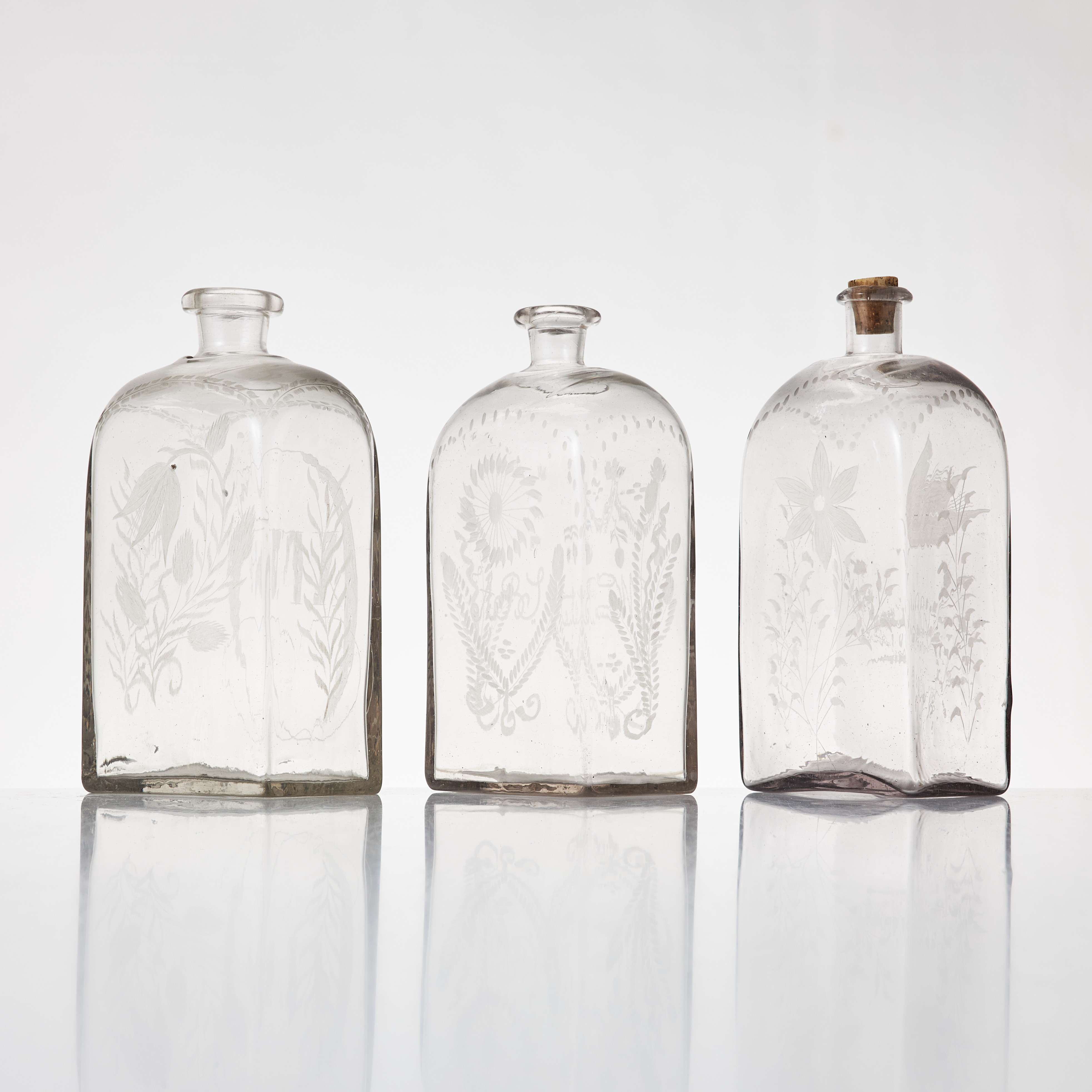 BRÄNNVINSPLUNTOR, 3 stycken, glas, 1800-takets mitt. Graverad dekor av blommor, en med Karl XIV Johans namnchiffer, en med monogram.