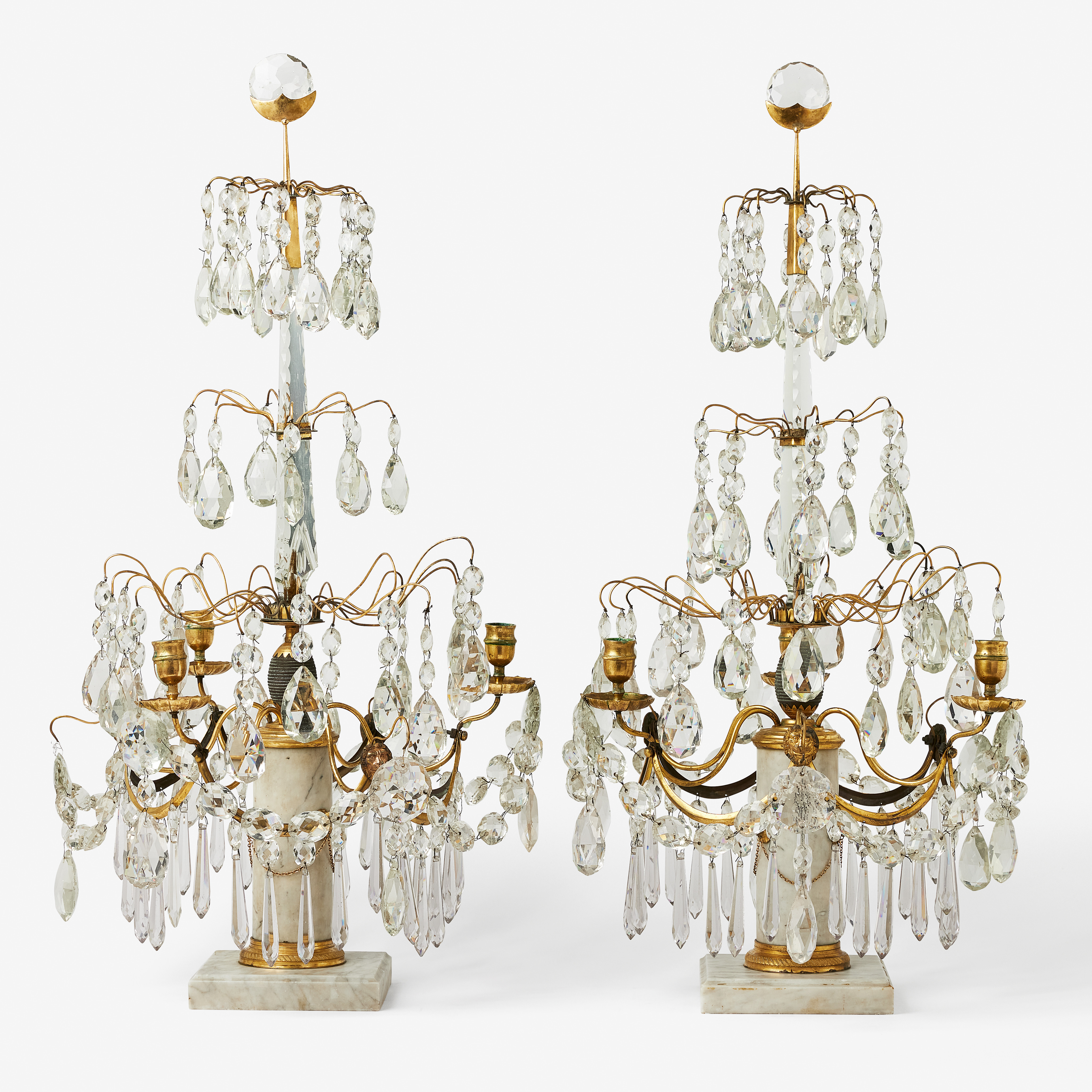 BORDSLYSTRAR, ett par, sengustavianska stockholmsarbeten, 1700-talets slut/omkring 1800, för vardera tre ljus, brännförgyllda monteringar i mässing, carraramarmor.