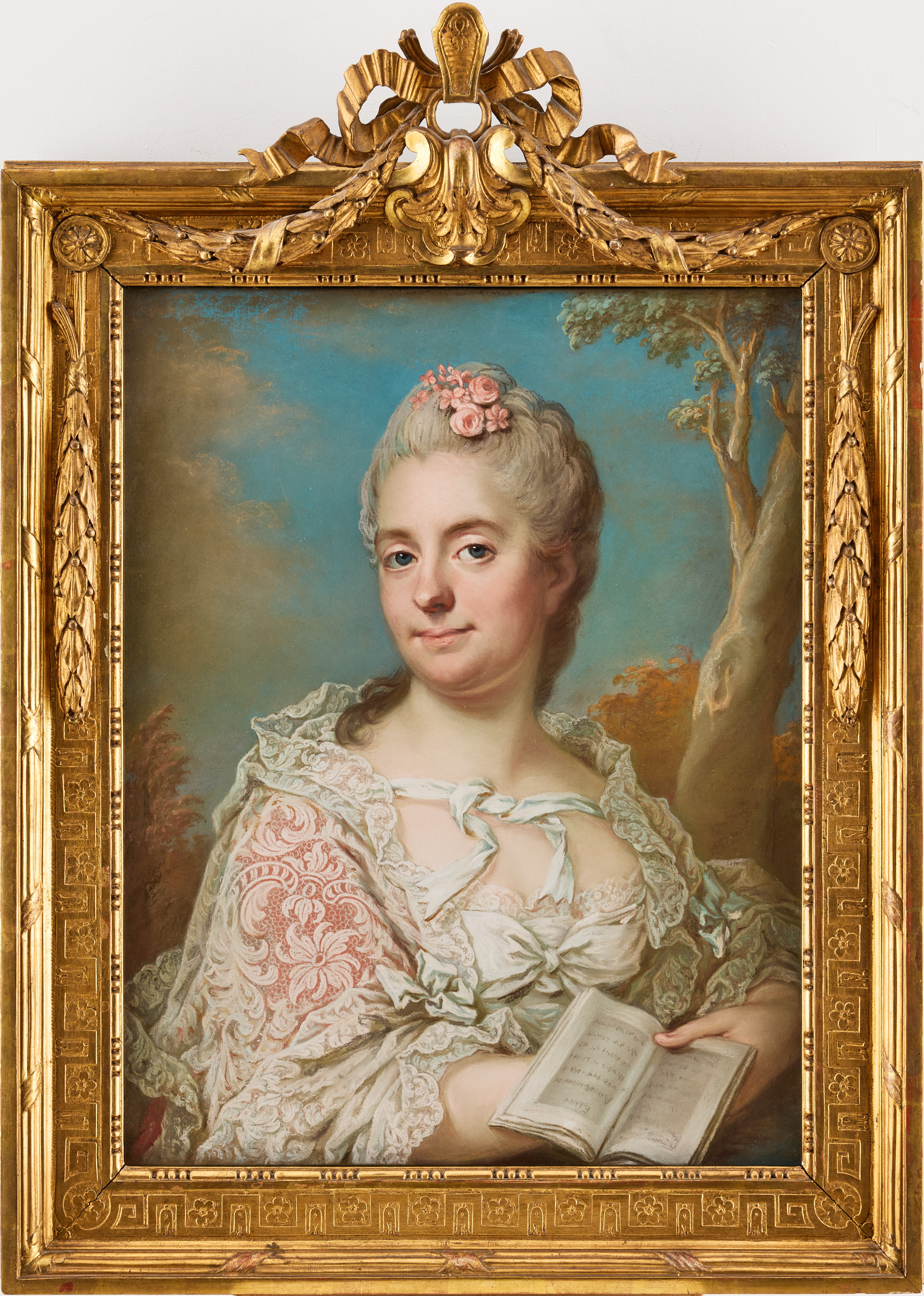 GUSTAF LUNDBERG (1695-1786). Porträtt föreställande Friherrinnan Catharina Magdalena Rålamb, född Boij (1725-1787) med en bok i handen, bärande en vit spetsmantilj och blommor i det pudrade håret.