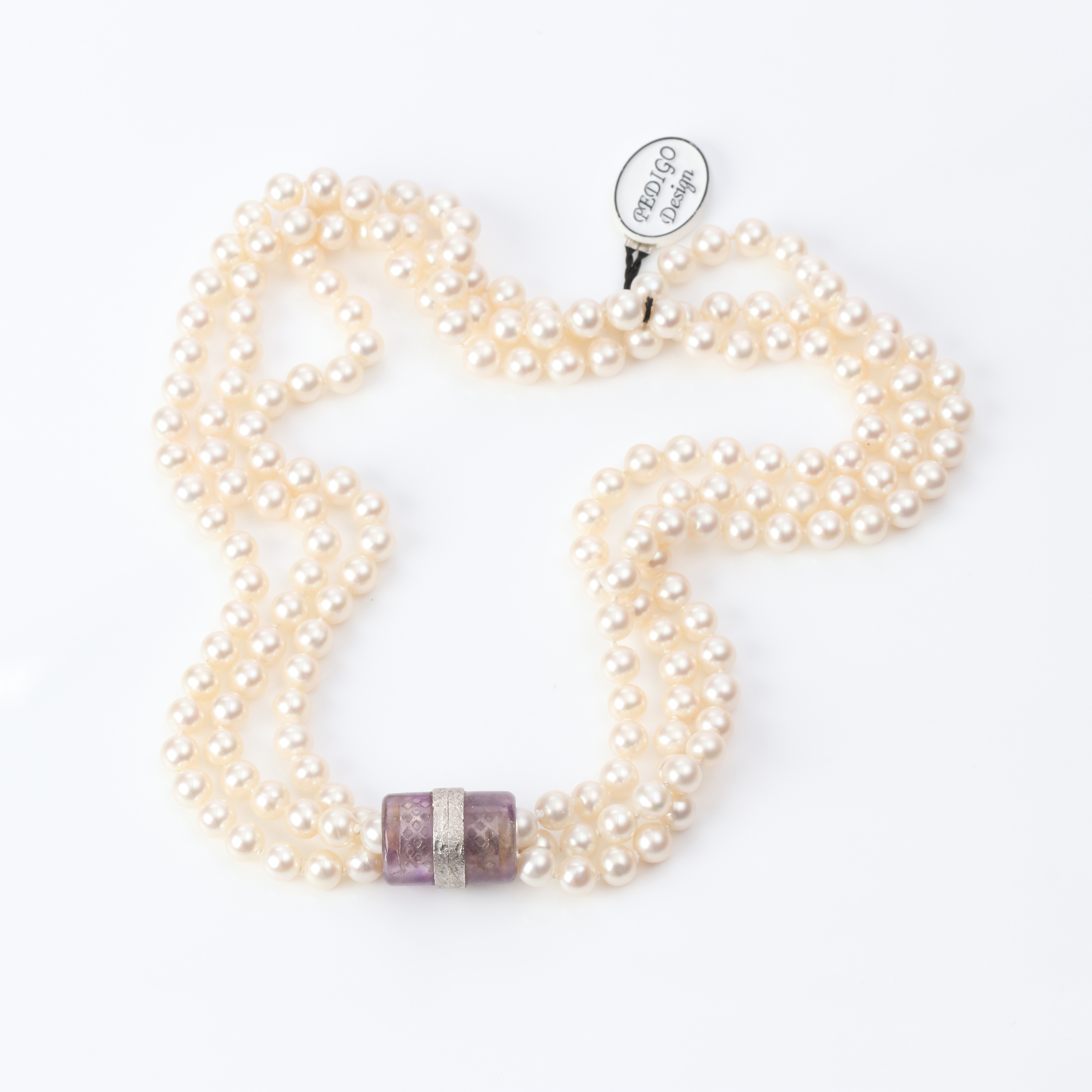 COLLIER, TRERADIG. Odlade pärlor, sannolikt saltvattenpärlor, lås i 18k vitguld med ametist.