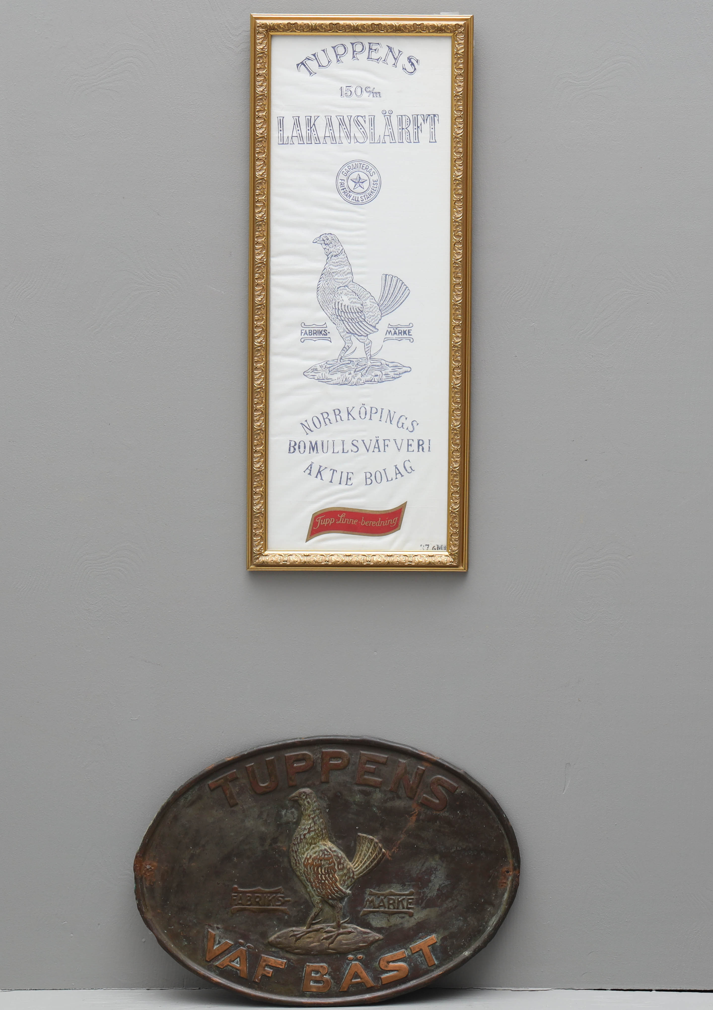 REKLAMSKYLTAR, 2 st, plåt och inranmad lakansväv, "Tuppens fabriksmärke Väf Bäst", 18/1900-tal.
