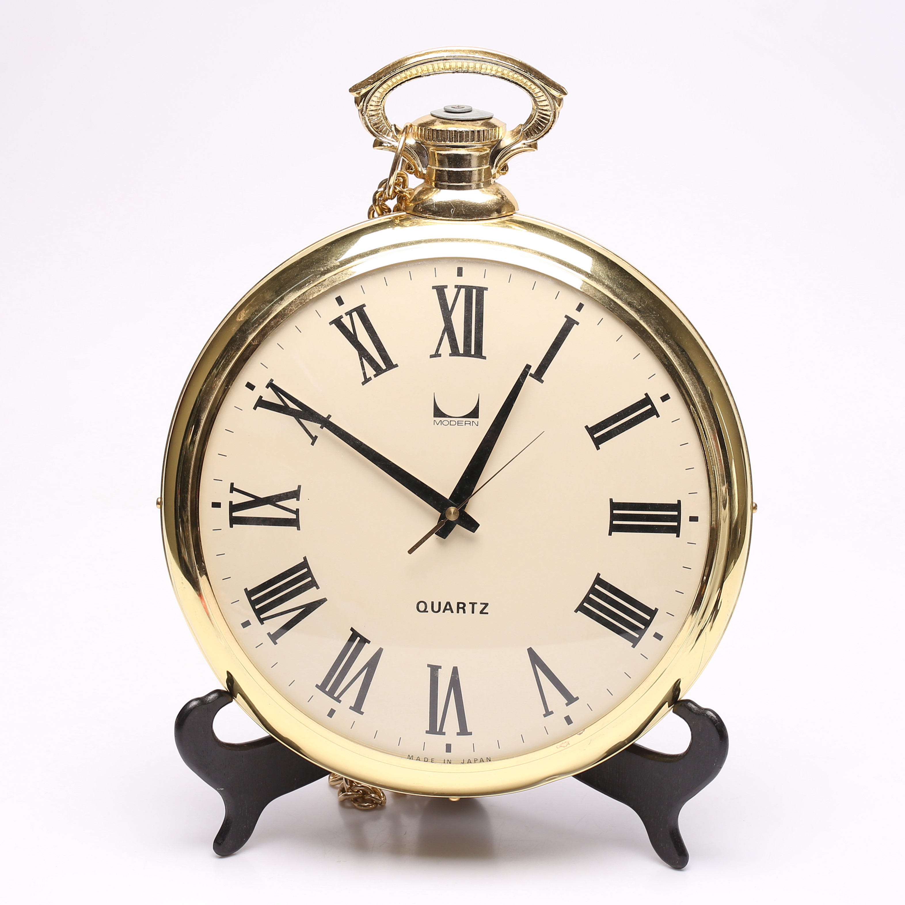 VÄGGUR, i form av fickur, med kedja, gulmetall och plast, Modern, 1900-talets andra hälft.