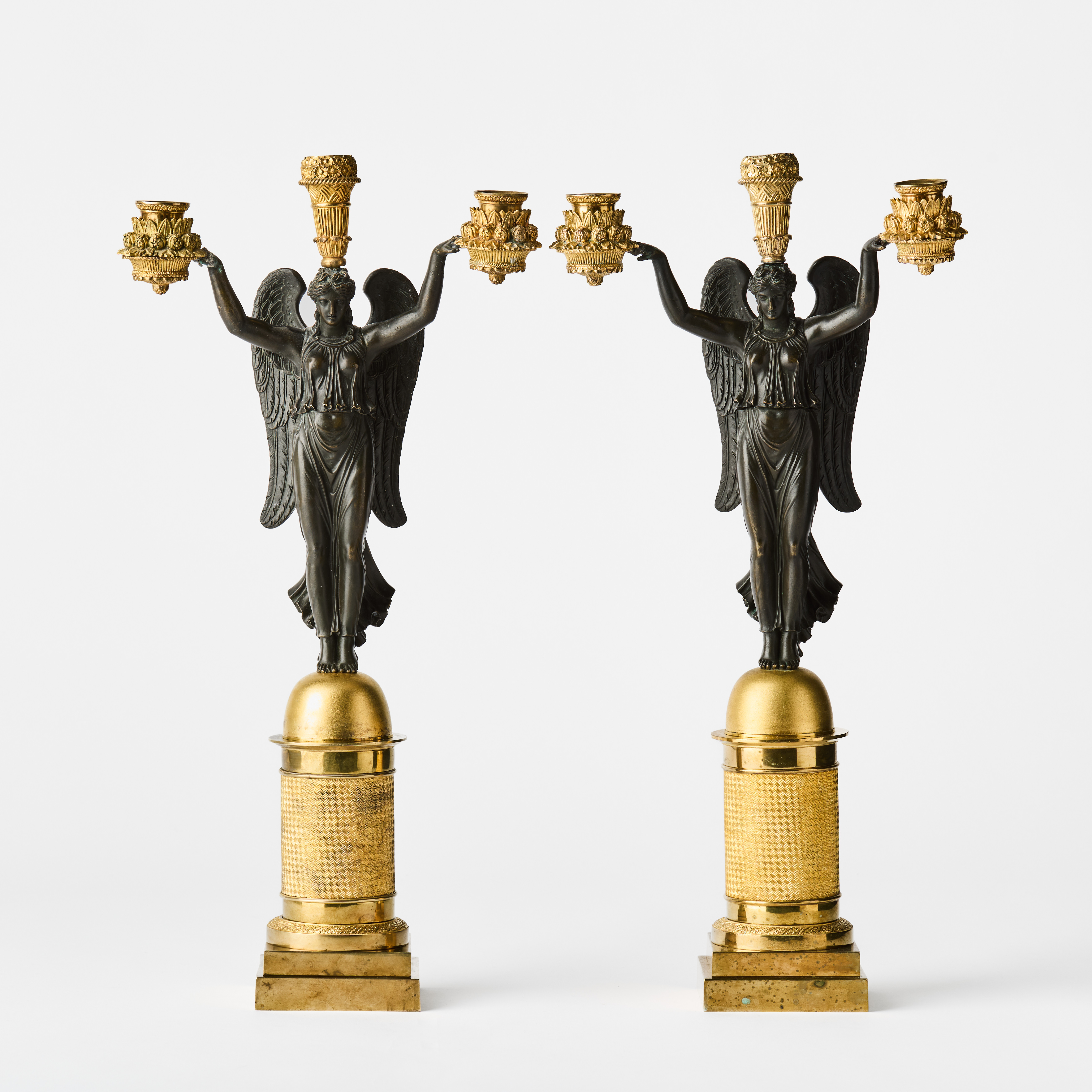 KANDELABRAR, ett par, parisarbeten i empire, 1800-talets första kvartal, för vardera tre ljus, förgylld och mörkpatinerad brons.