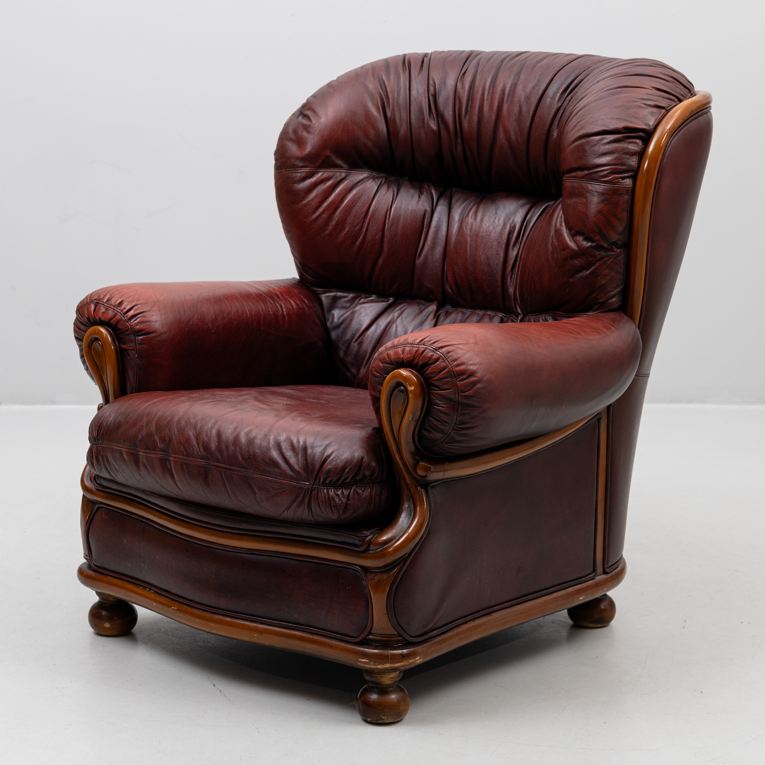 FÅTÖLJ, Chesterfieldmodell, vinrött skinn med brunbetsad stomme.