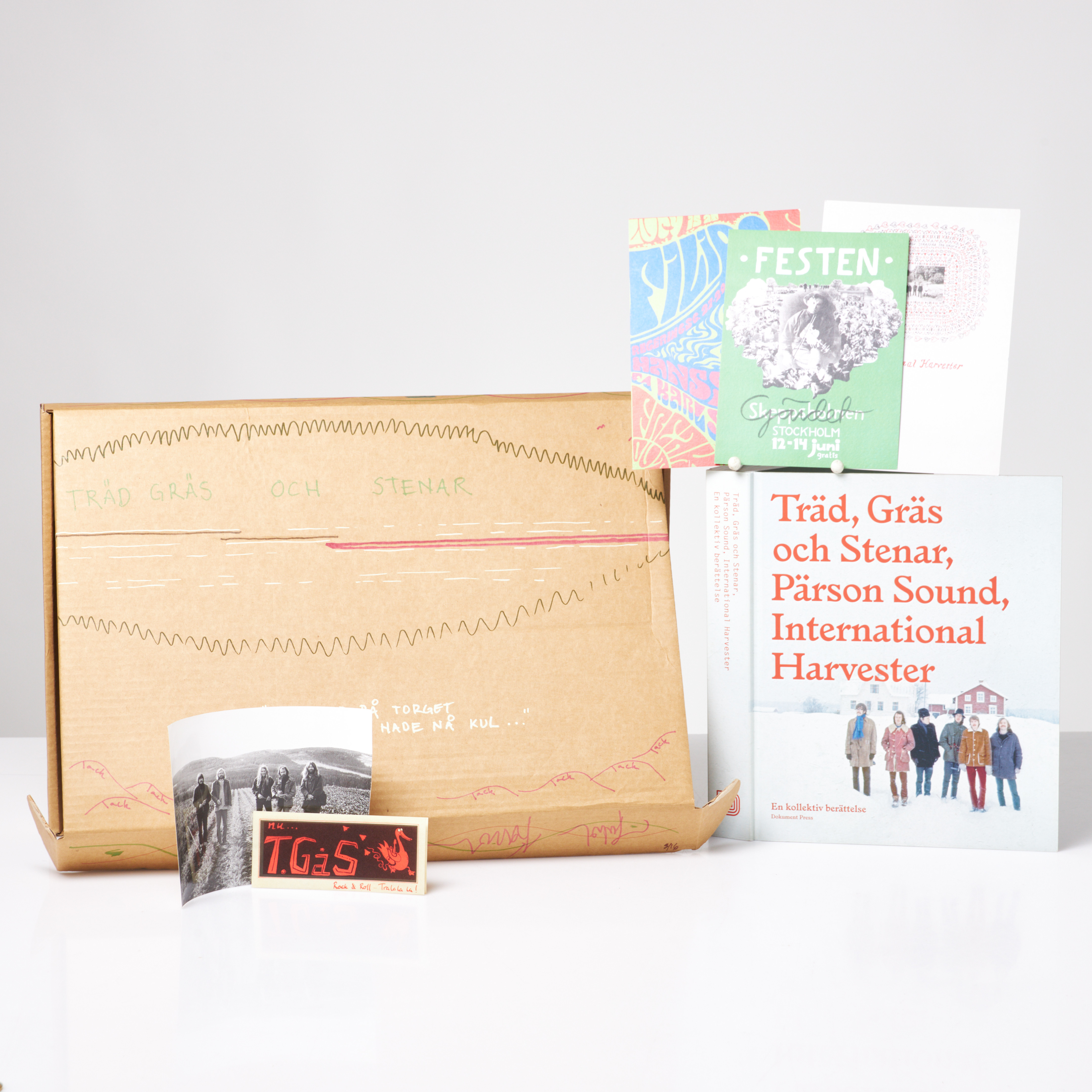 TRÄD, GRÄS & STENAR BOX, nummer 3/16, kartong signerad och bemålad av bandet, innehållandes boken Träd, Gräs och Stenar: en kollektiv berättelse, fotografi, klistermärke, trycksaker, samt 5 st affischer.