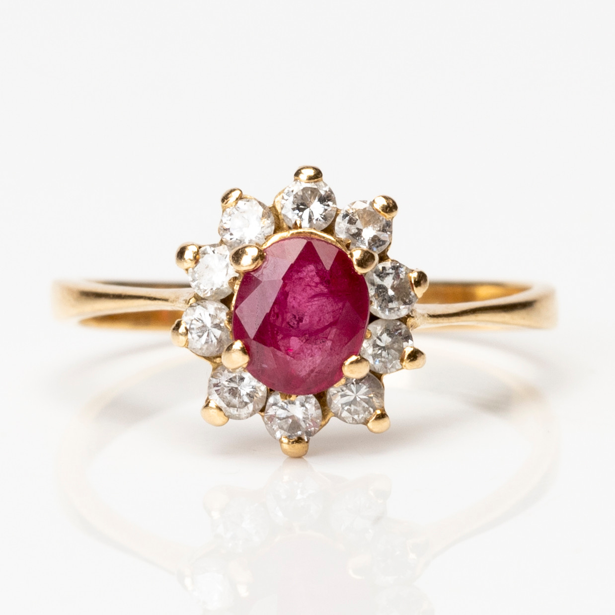 CARMOSÉRING, 18K guld med tio briljantslipade diamanter om ca 0,30ctw samt facettslipad röd sten, 1900-talets andra hälft.