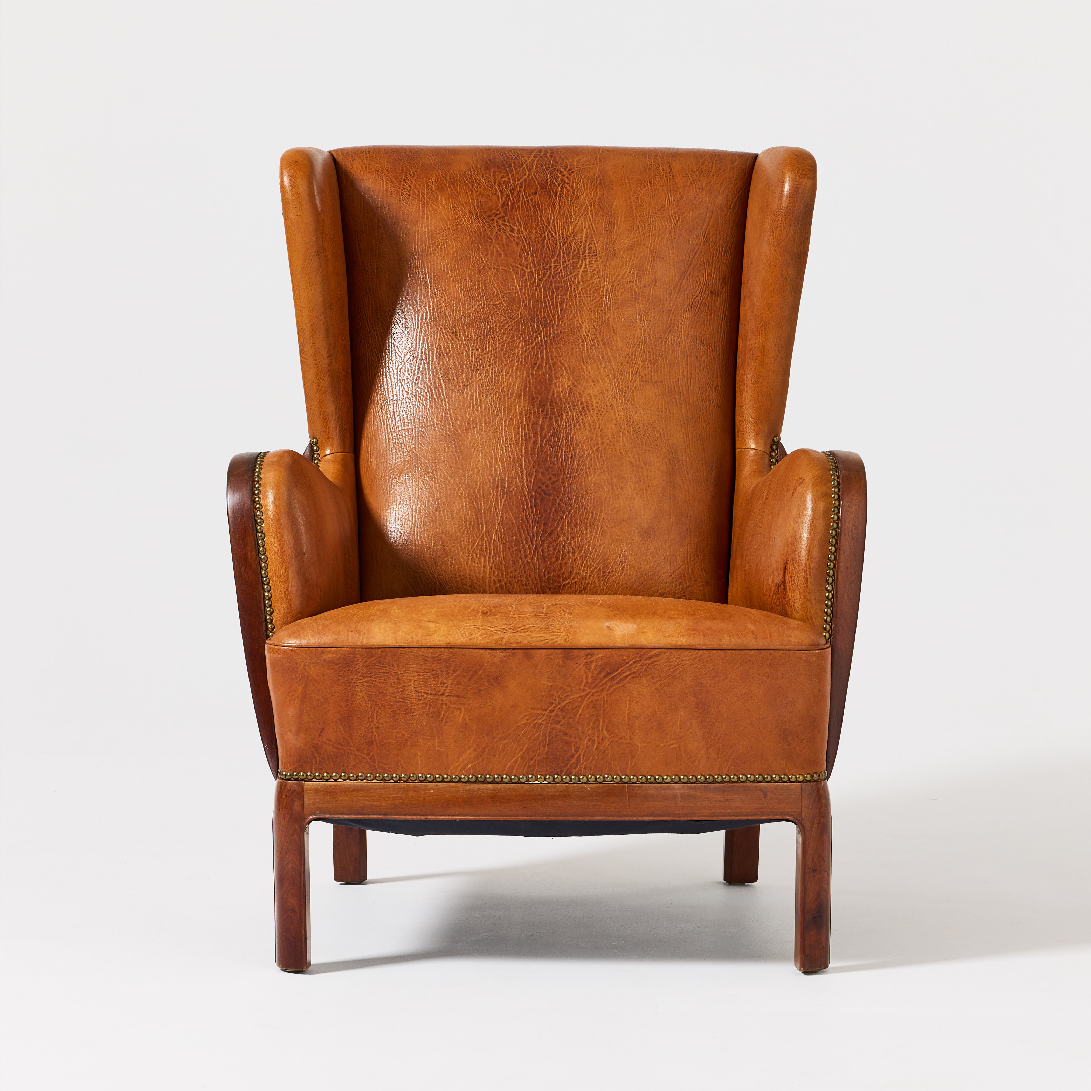 FRITS HENNINGSEN. Fåtölj, Danmark 1930-tal, mahogny, pärlspikad klädsel i brunt läder.