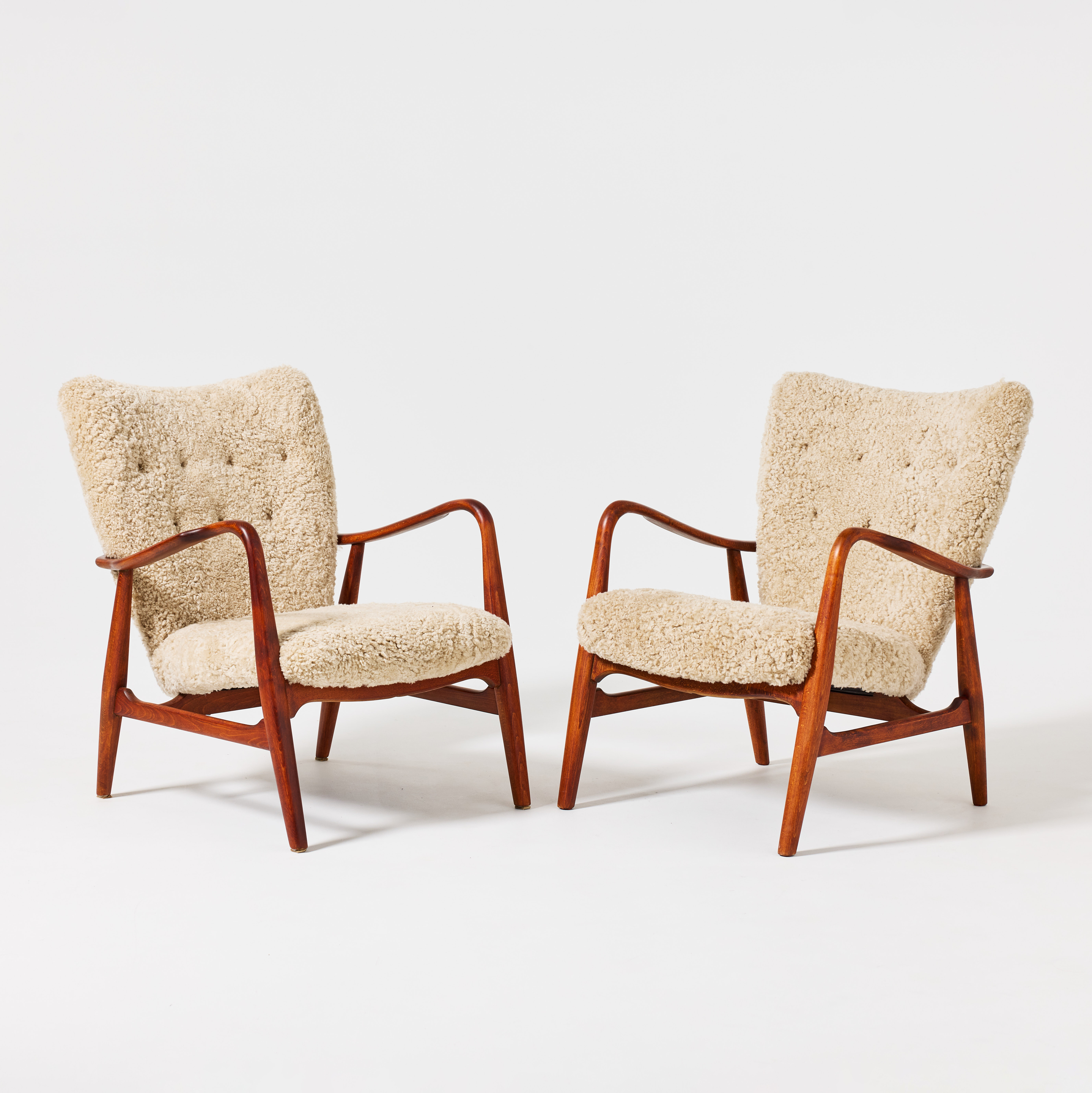 HENRY SCHUBELL. Fåtöljer, ett par, Vik & Blindheim, Danmark, 1950-tal, betsad bok, stoppad rygg och sits klädda i fårskinn, ryggen med klädda knappar.