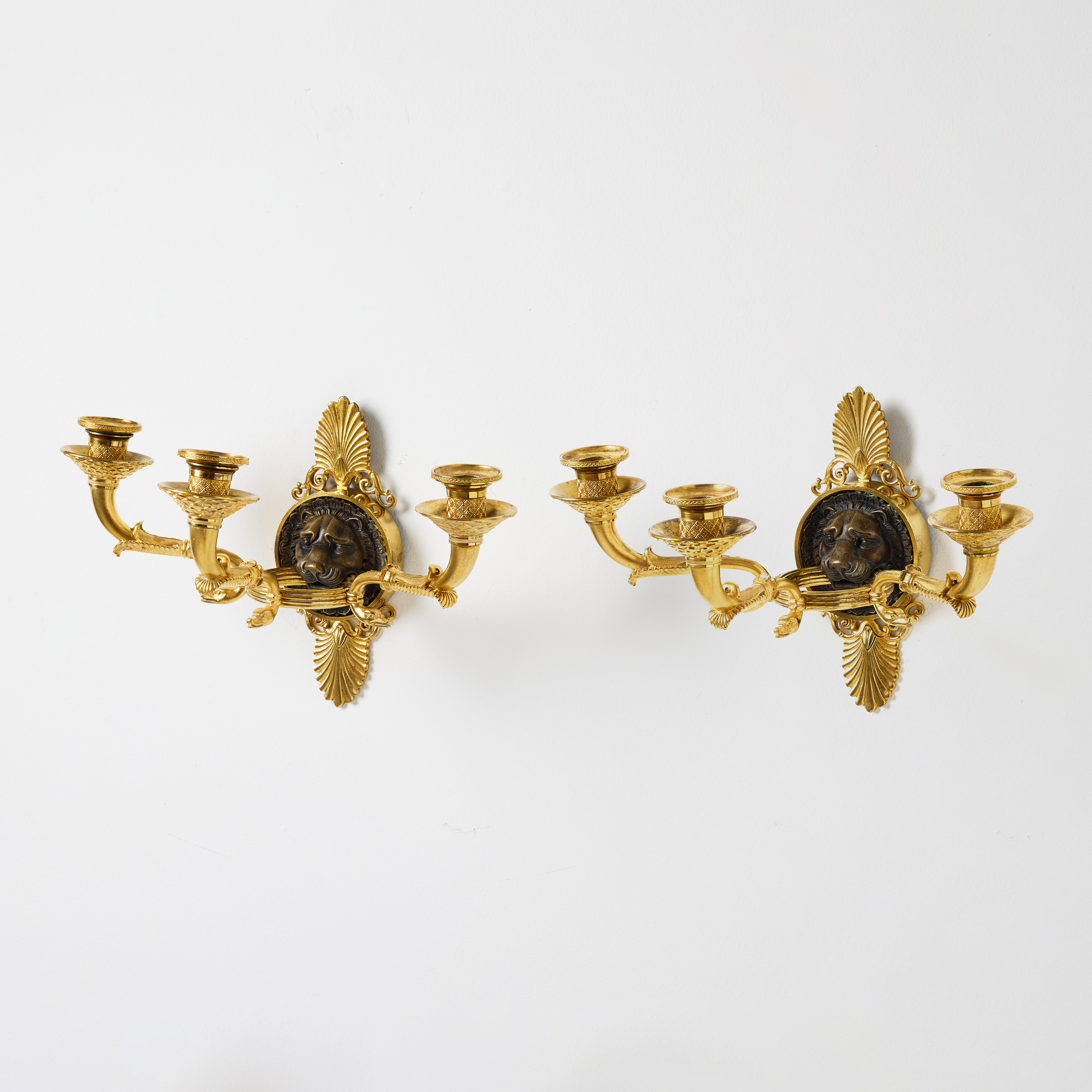 APPLIQUER, ett par, parisarbeten i empire, 1800-talets första kvartal, för vardera tre ljus, gjutarmärkta Chibout (Pierre Chibout, bronsgjutare i Paris omkring 1806-1824), brännförgylld och mörkpatinerad brons.