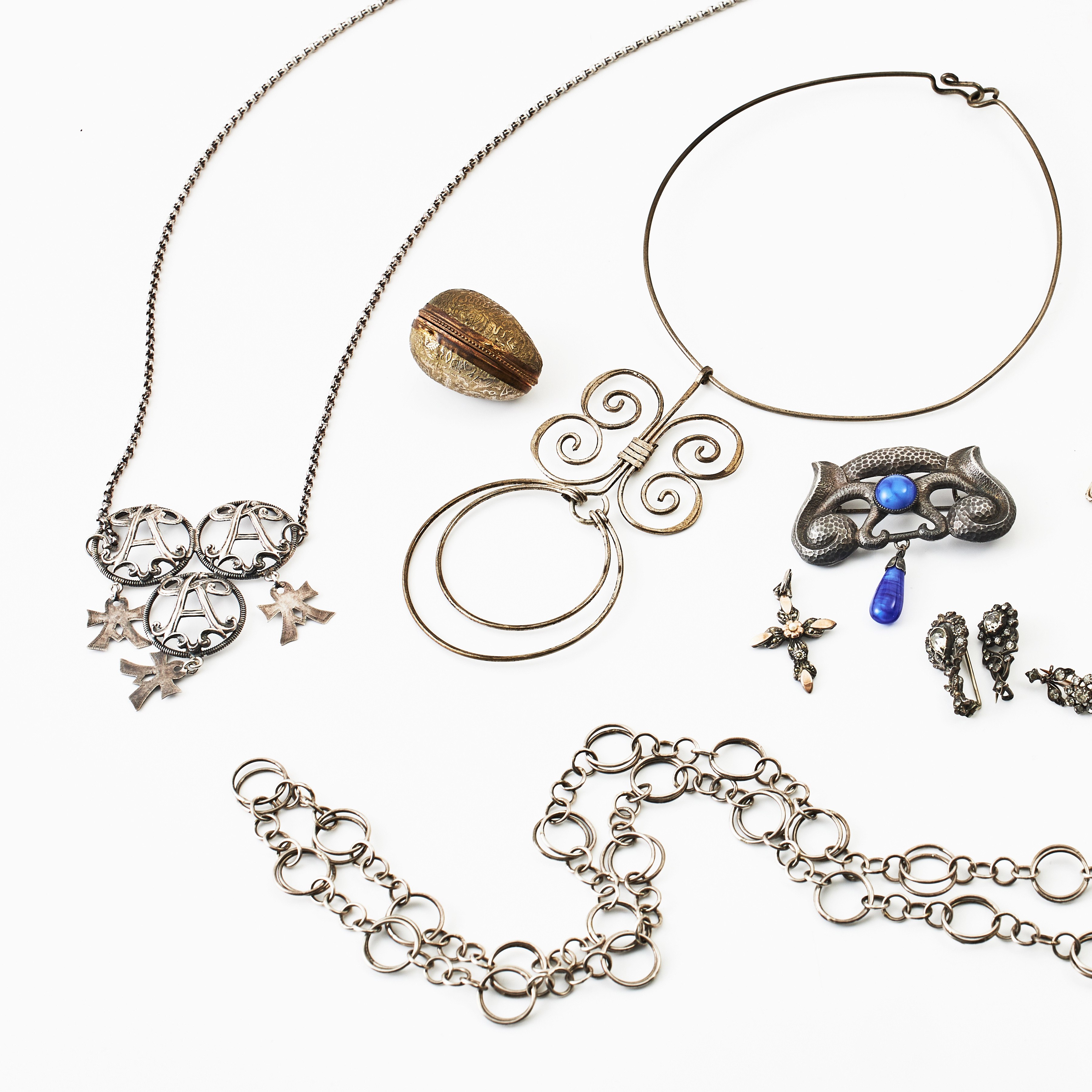BROSCHER, 4 st., varav 3 med fasettslipade glasstenar resp. i jugend med dropp-och cabochonslipad glassten i blått, HALSBAND, 3 st., HÄNGEN, 2 st., varav ett i form av kors med dekor av markasiter, ETUI, i form av ägg, delvis silver.