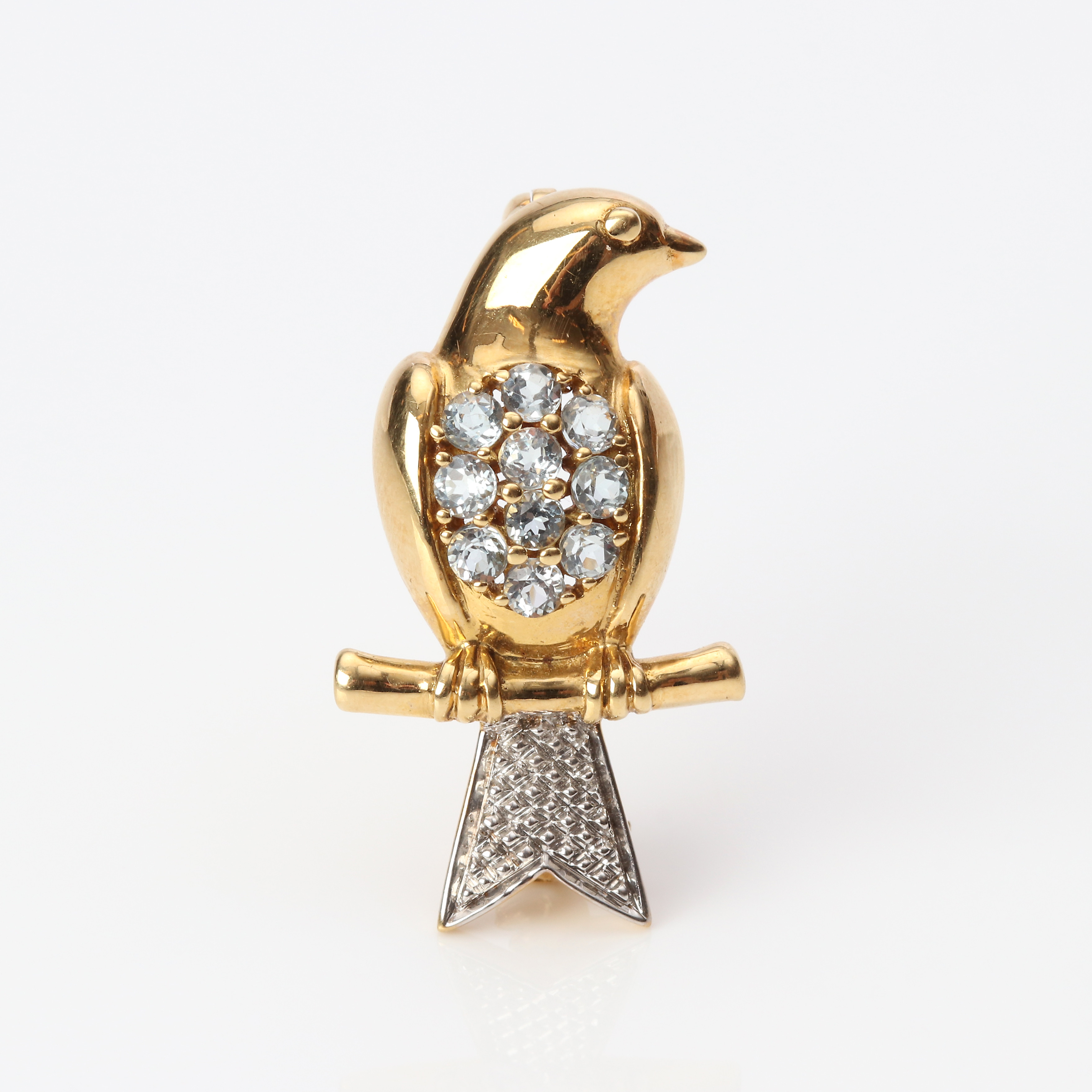 BROSCH I FORM AV FÅGEL. 18k röd- och vitguld med ljust blå topaser, totalvikt ca 3,8 gram.