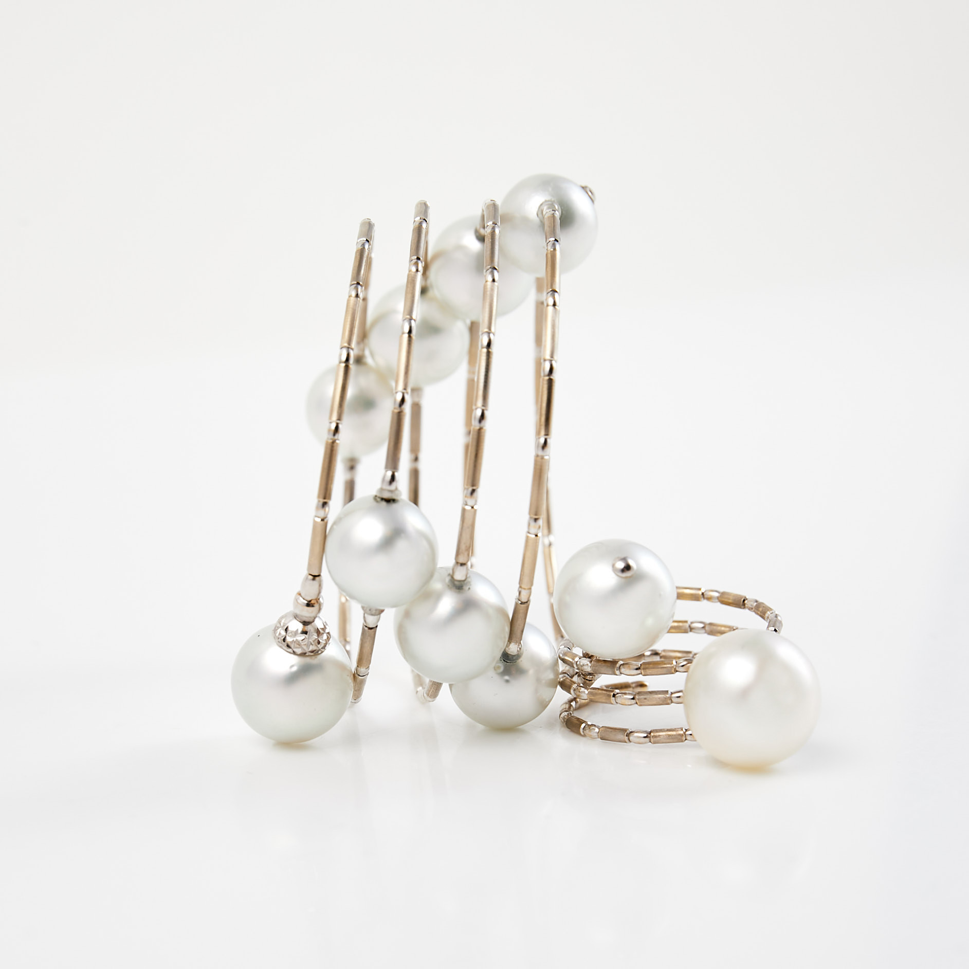 YANA NESPER. 2 dlr, "WRAPme", ARMBAND samt RING, 18 k vitguld, odlade south seapärlor, dekor av fasettslipade safirer, justerbar storlek, i originalask.