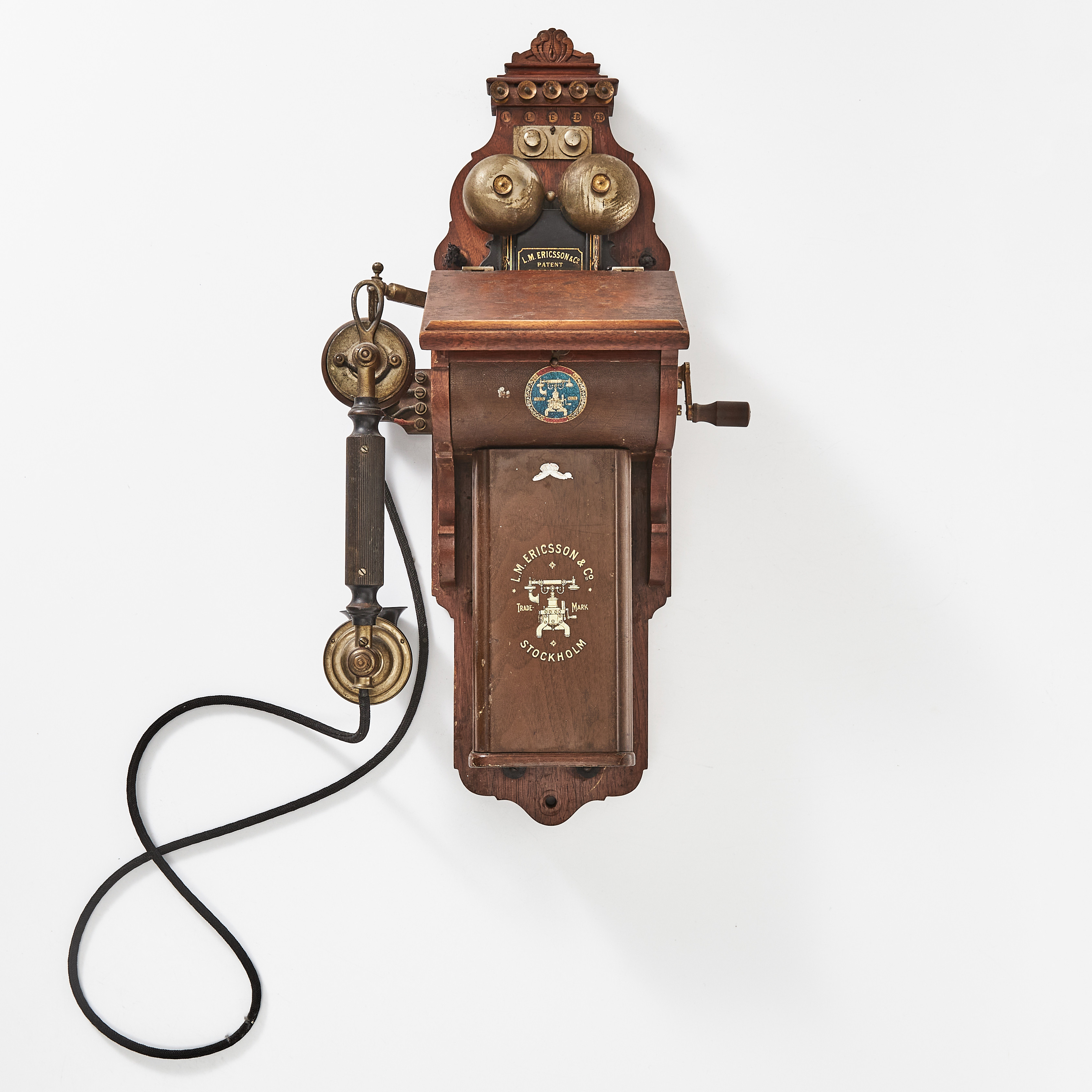 TELEFON, väggmodell, LM Ericsson, modell AB160, fodral i valnöt, batterilåda med litograferad dekor imiterande valnöt, exemplaret från år 1909.