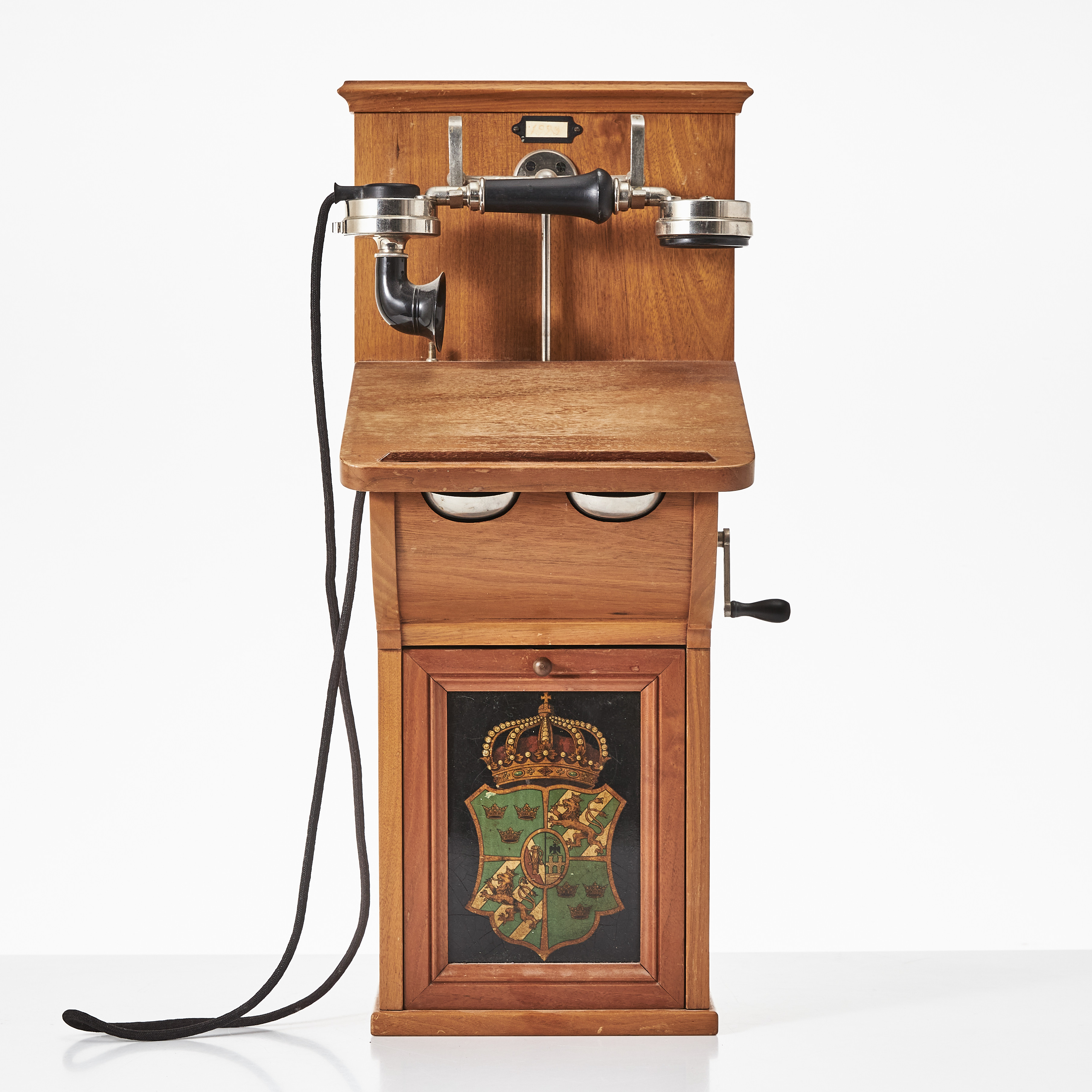 VÄGGTELEFON, Kungliga Telegrafverkets Verkstad, Stockholm, modell AC 150 / TVM, valnöt, batteriluckan i metall med litograferad dekor av stora riksvapnet, modellen tillverkad mellan 1893 och 1925.