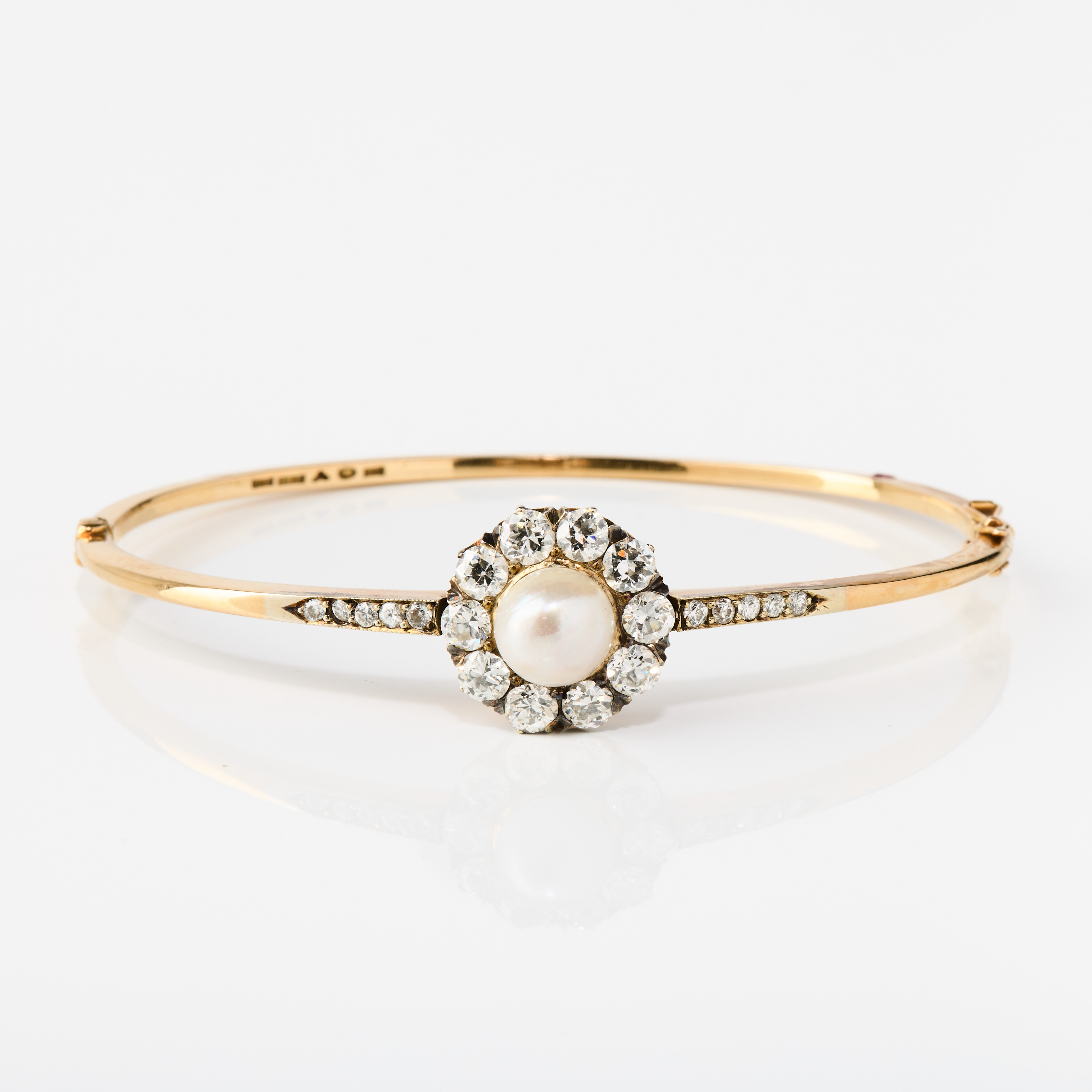 ARMRING, 18K guld med en buttonpärla pärla, möjligen naturlig och diamanter, Stockholm 1904.