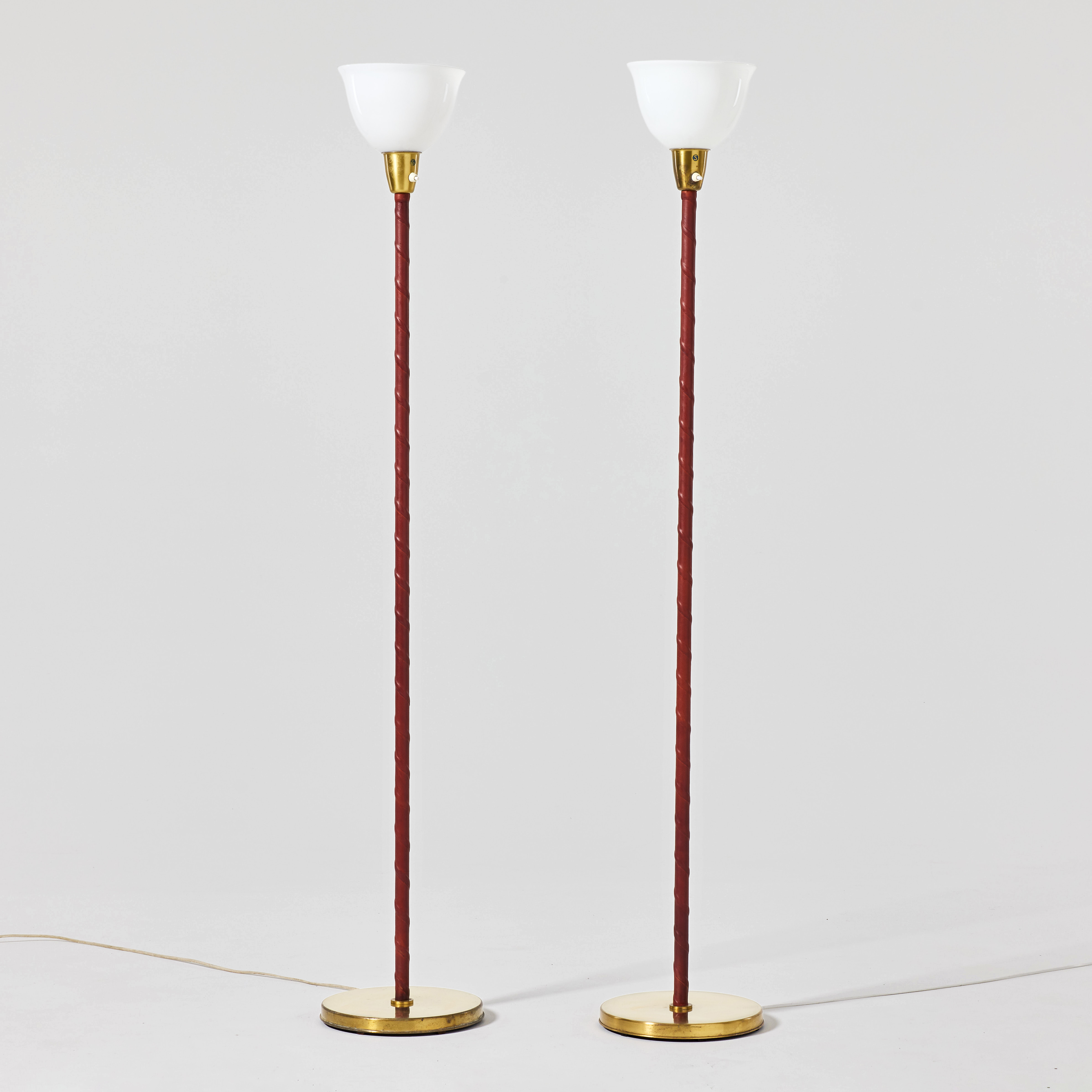 BERGBOM. Golvlampor, ett par, 1950-tal, modell G-05, mässing med pelare lindade i cognacsfärgat läder.