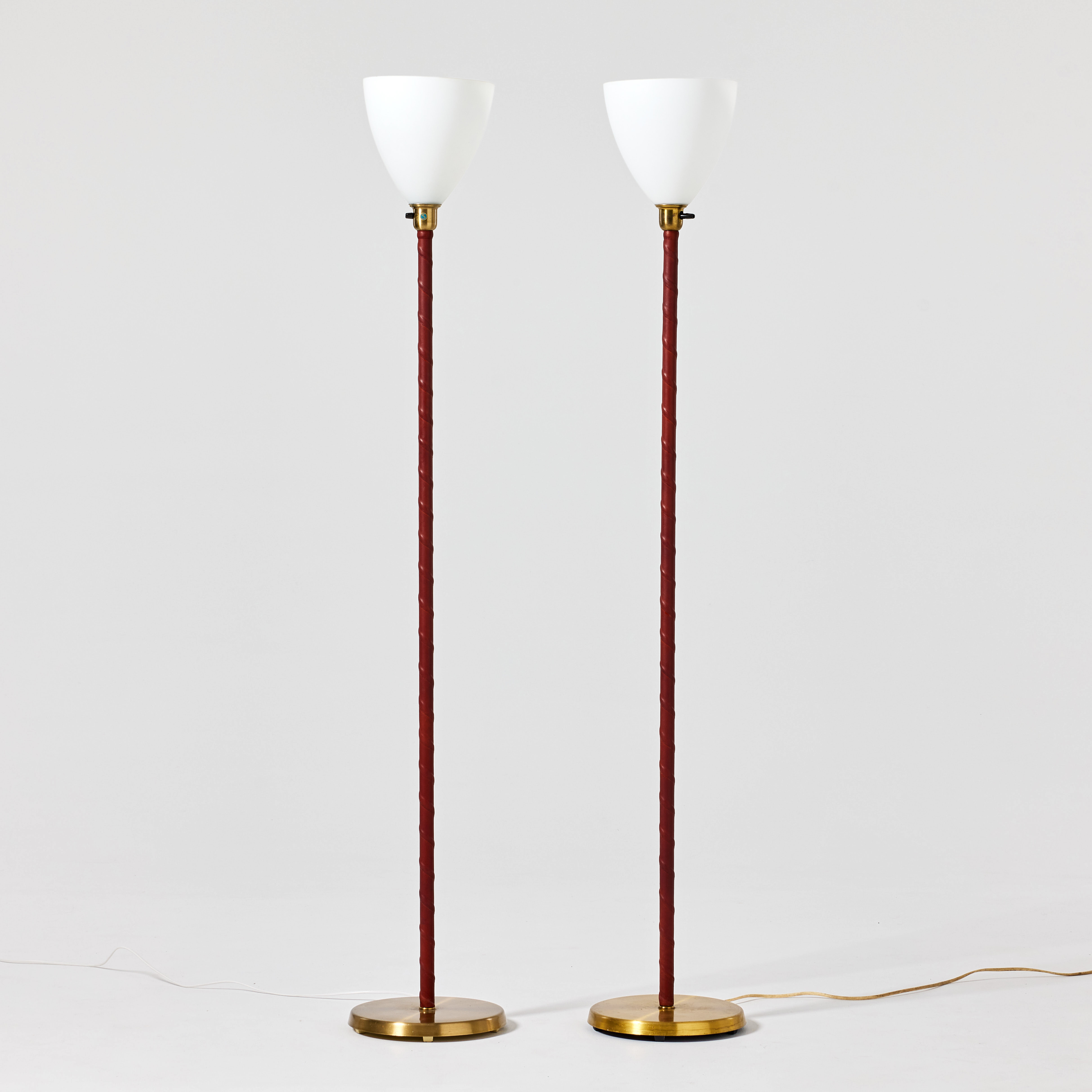 ASEA BELYSNING. Golvlvampor, ett par, 1950-tal, mässing och glas med pelare lindade i cognacsfärgat läder.