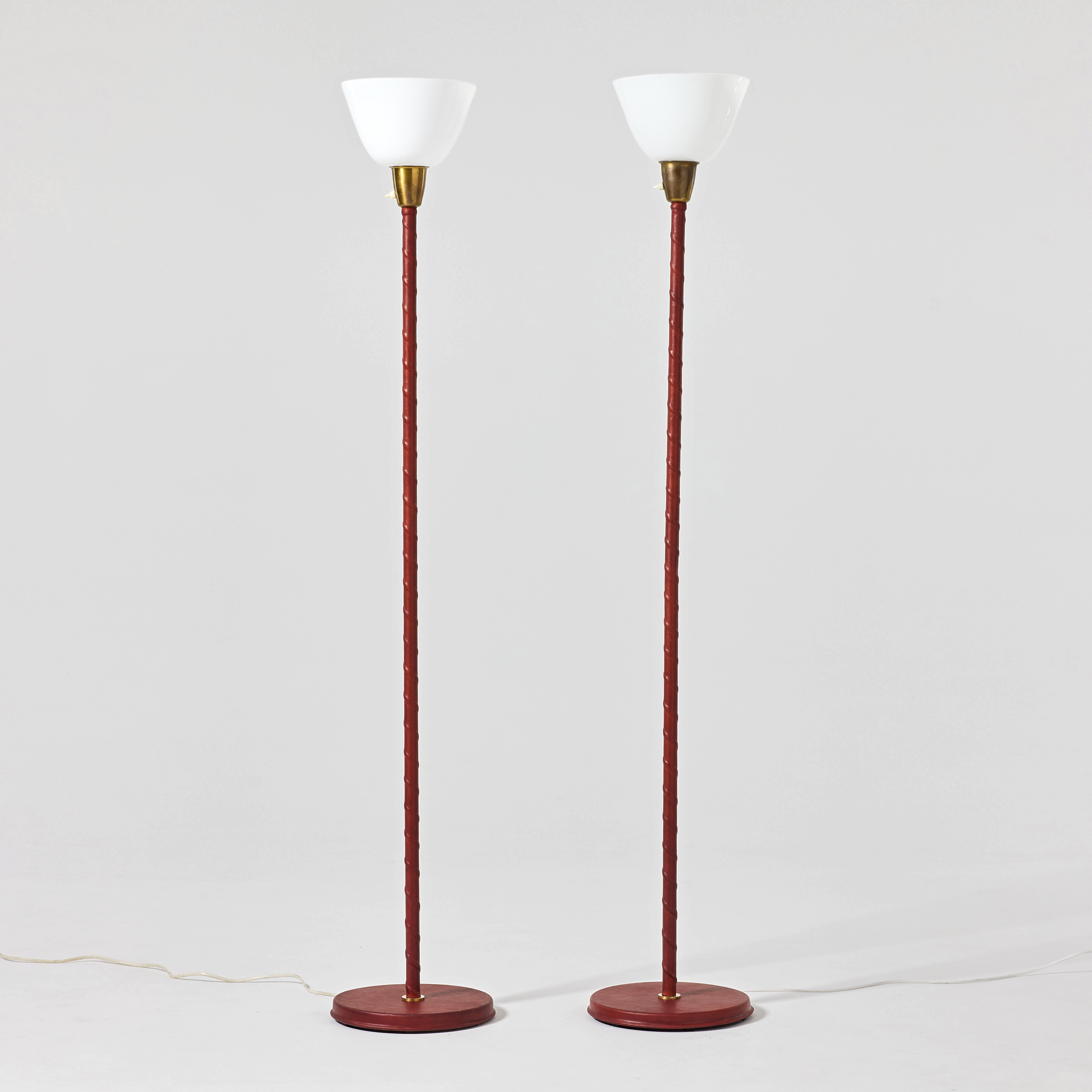 BERGBOM. Golvlampor, ett par, 1950-tal, modell G-05, mässing med pelare lindade i cognacsfärgat läder.