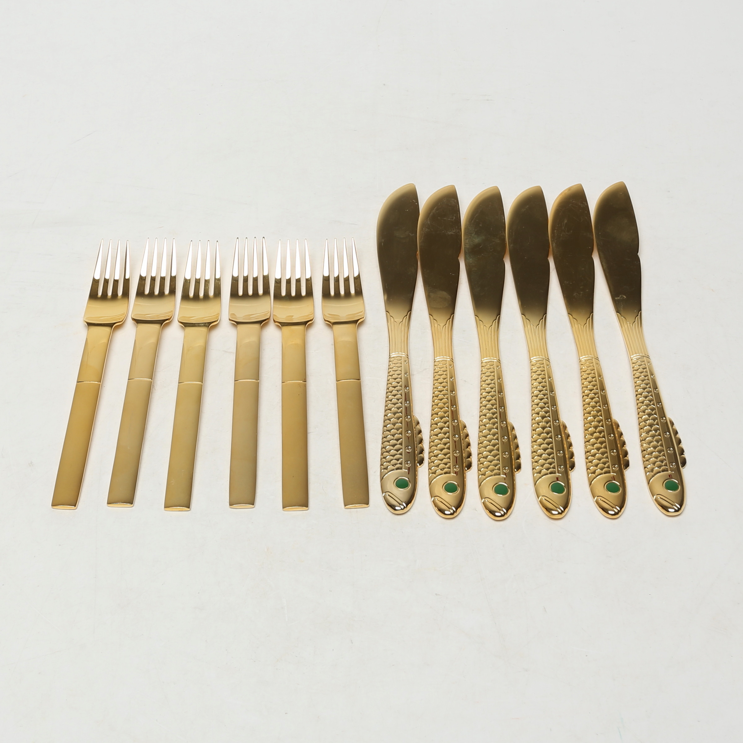 GUNNAR CYRÉN. NOBELFISKBESTICK, totalt 12 delar, förgylld metall.