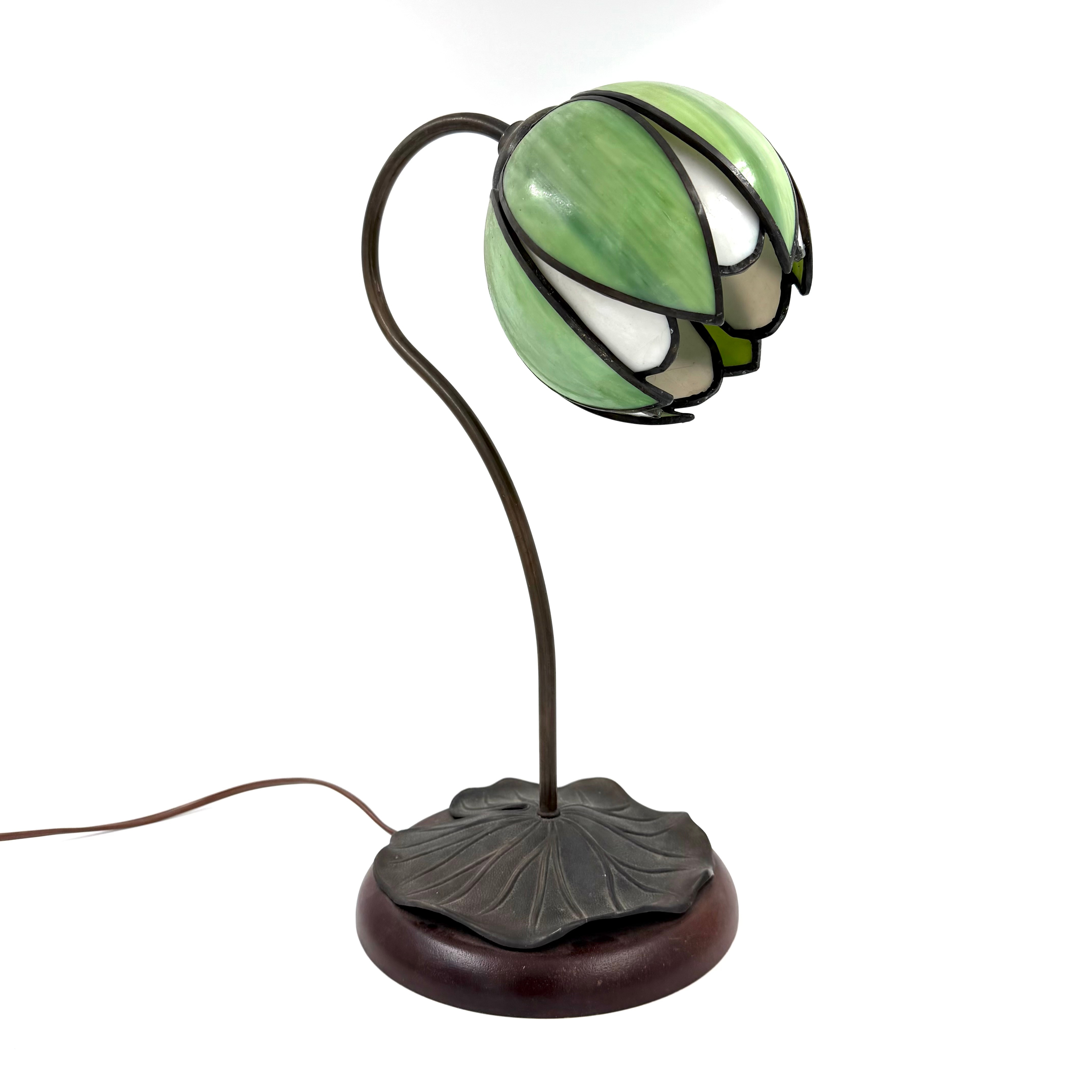 BORDSLAMPA, 1900-talets andra hälft, tiffanystil, patinerad metall samt mörkbetsat trä, form av näckros med bladformation.