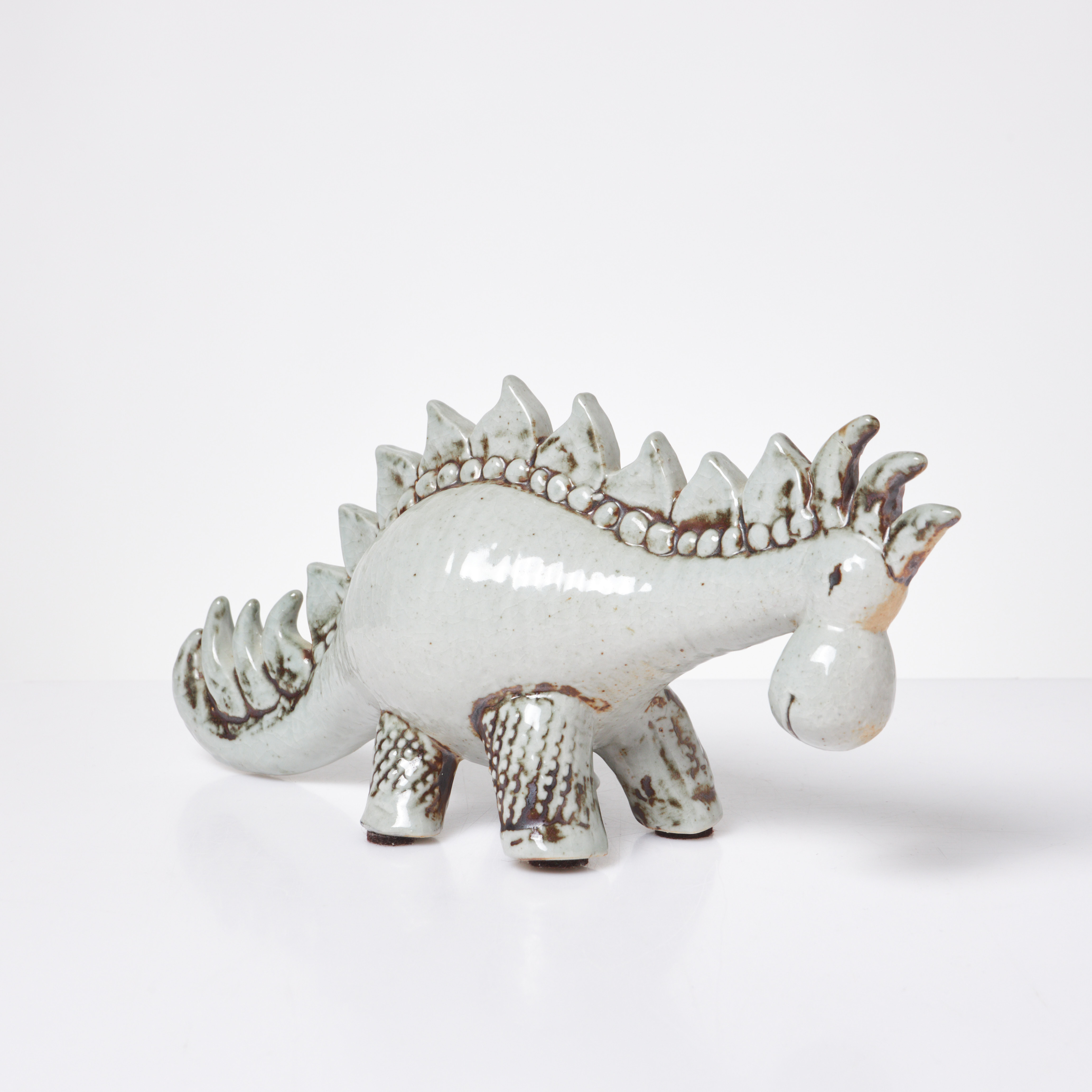 LISA LARSON. Dinosaurie, Gustavsberg, stengods, glaserad i ljus celadon, inpressad dekor, signerad i blyerts samt etikett.