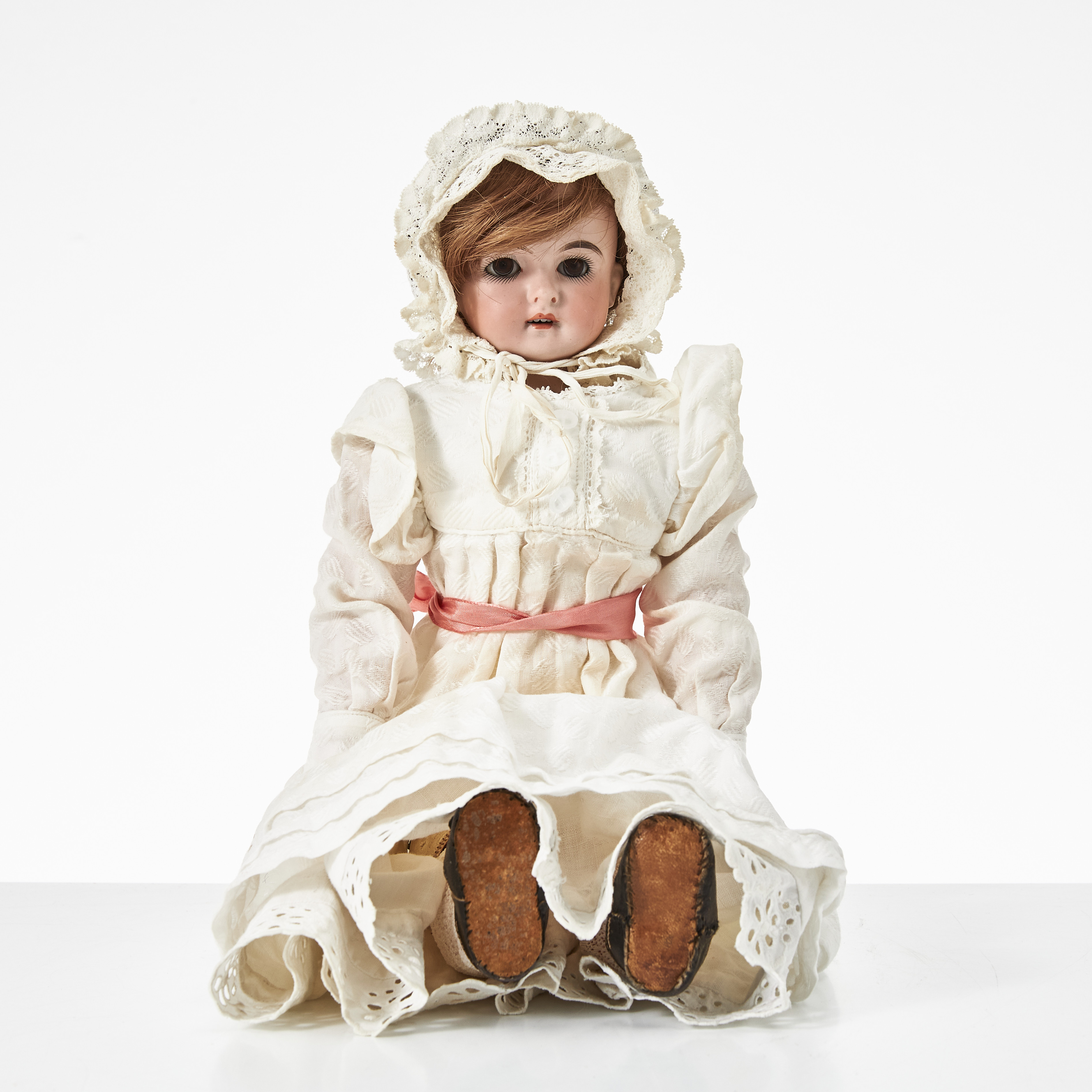KLING BISKVI FLICKDOCKA, omkring 1900, huvud med sköld märkt “124, klocka, 4", bruna blundögon i glas, brun hårperuk, öppen mun med tänder, stoppad och ledad kropp, klänning med spets, vita underkläder, strumpor, skor, 1800-talets senare del/omkring 1900.