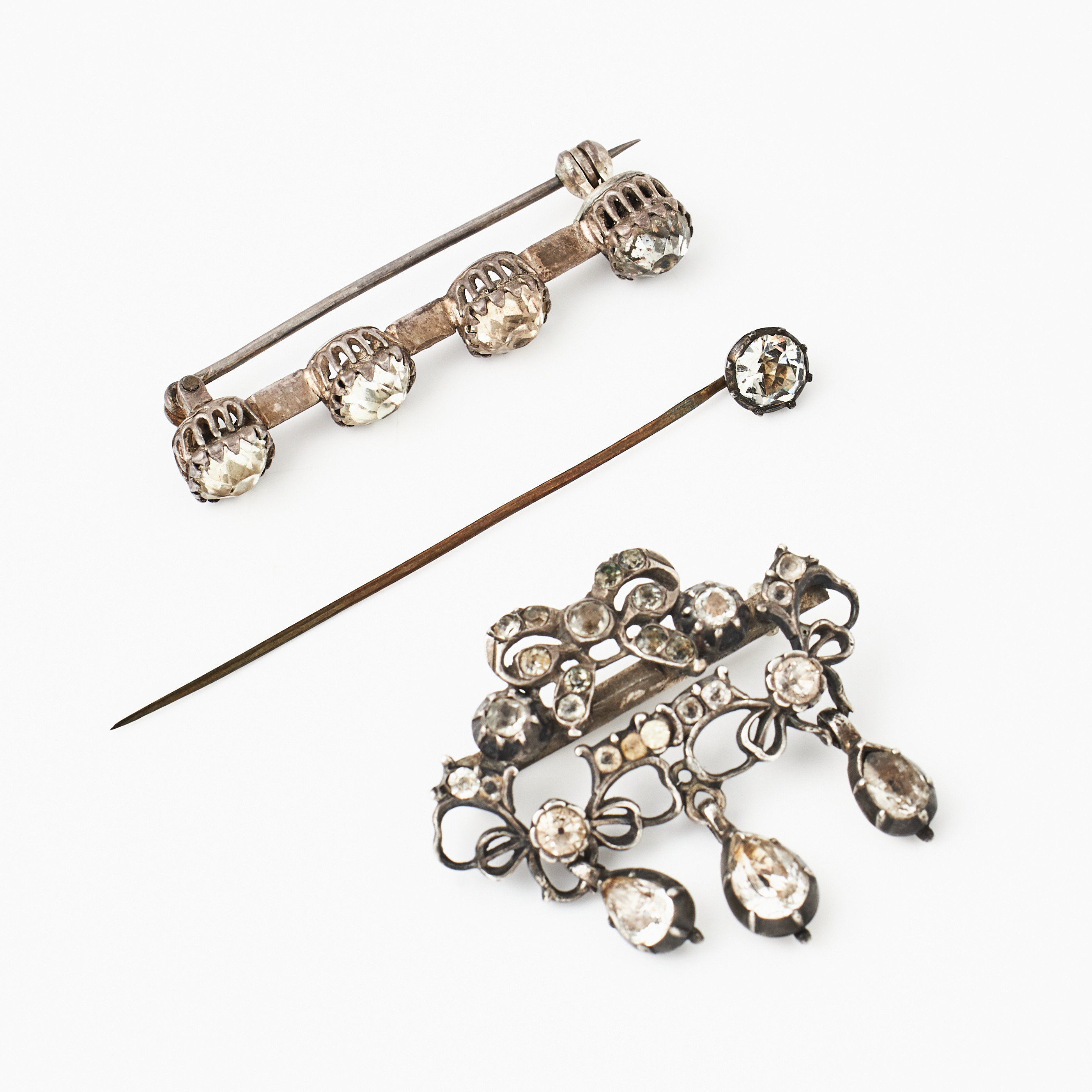 BROSCHER, 2 st., delvis silver, dekor med äldre fasettslipade glasstenar, varav en brosch med 3 pendeloqueformade kläppar, i girandole modell, 1700-talets slut/omkring 1800, KRAVATTNÅL, oädel metall, fasettslipad glassten i kistfattning, omkring 1800.