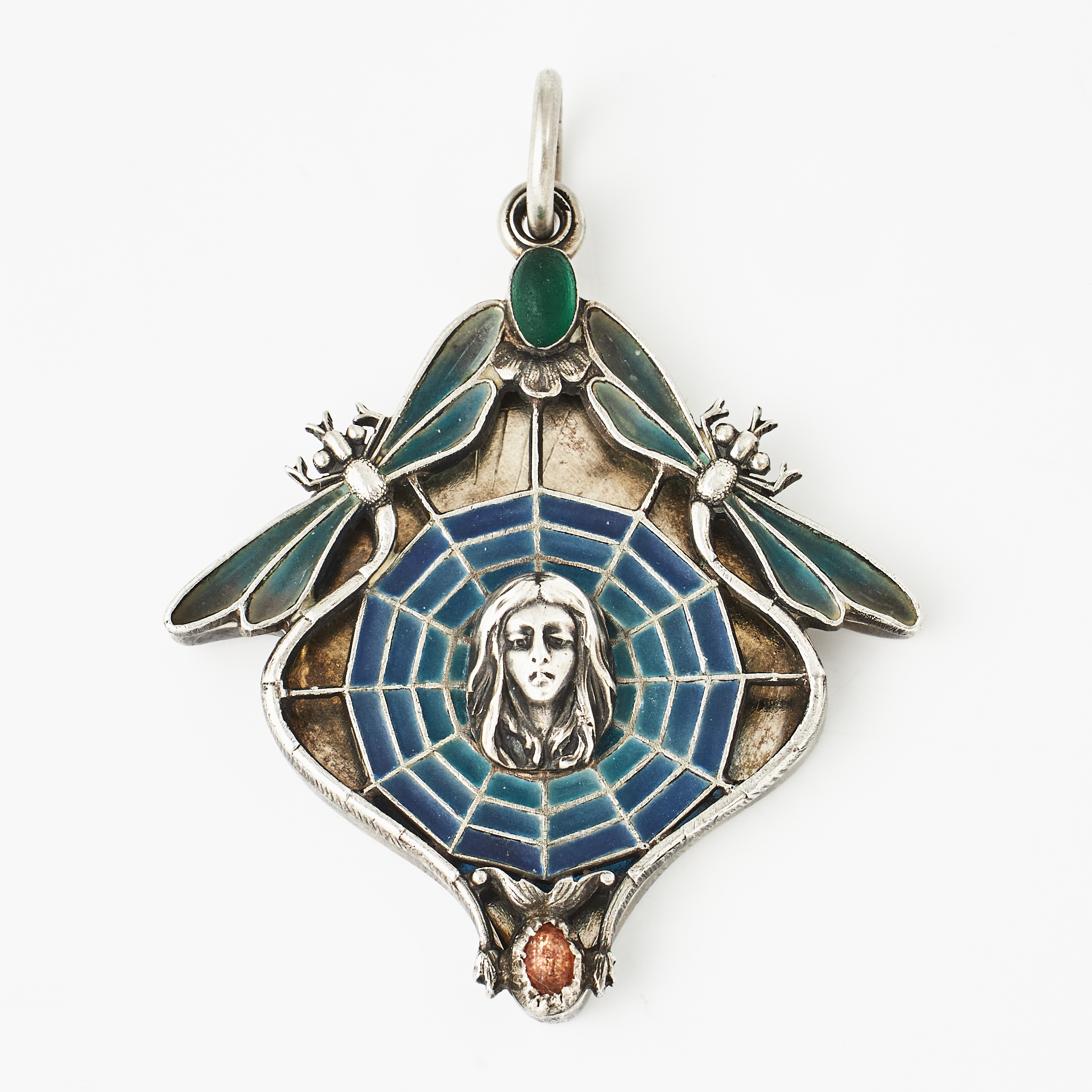 HÄNGE, silver/900, öppningsbart som skall innehålla en spegel, dekor av ett ansikte inuti ett spindelnät flankerat av 2 trollsländor, med s.k. plique-à-jour emalj, 2 cabochonslipade glasstenar, Art Nouveau, sannolikt Frankrike, omkring 1900.