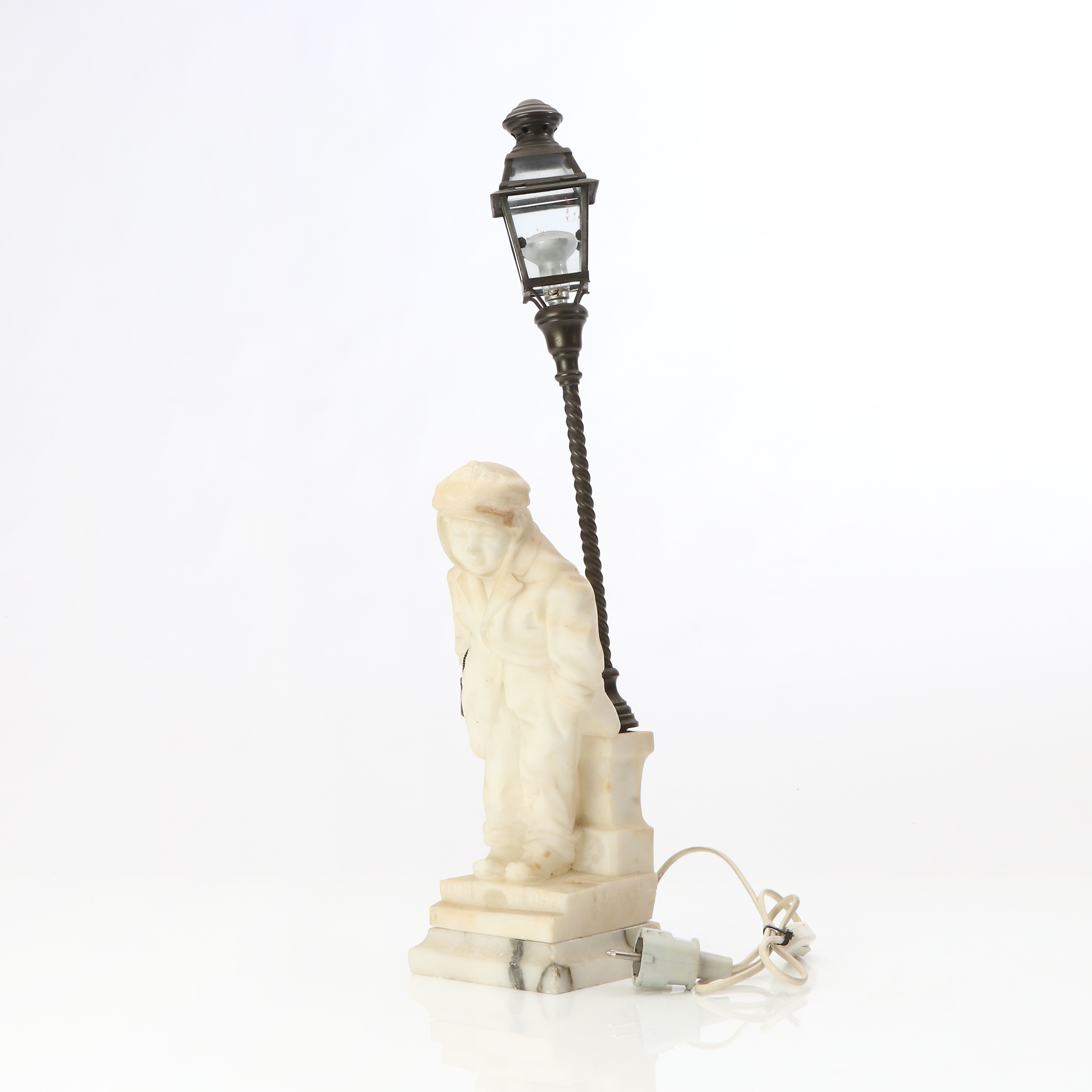 BORDSLAMPA. Alabaster och mässing. I form av pojke och lyktstolpe. 1900-talets första hälft.