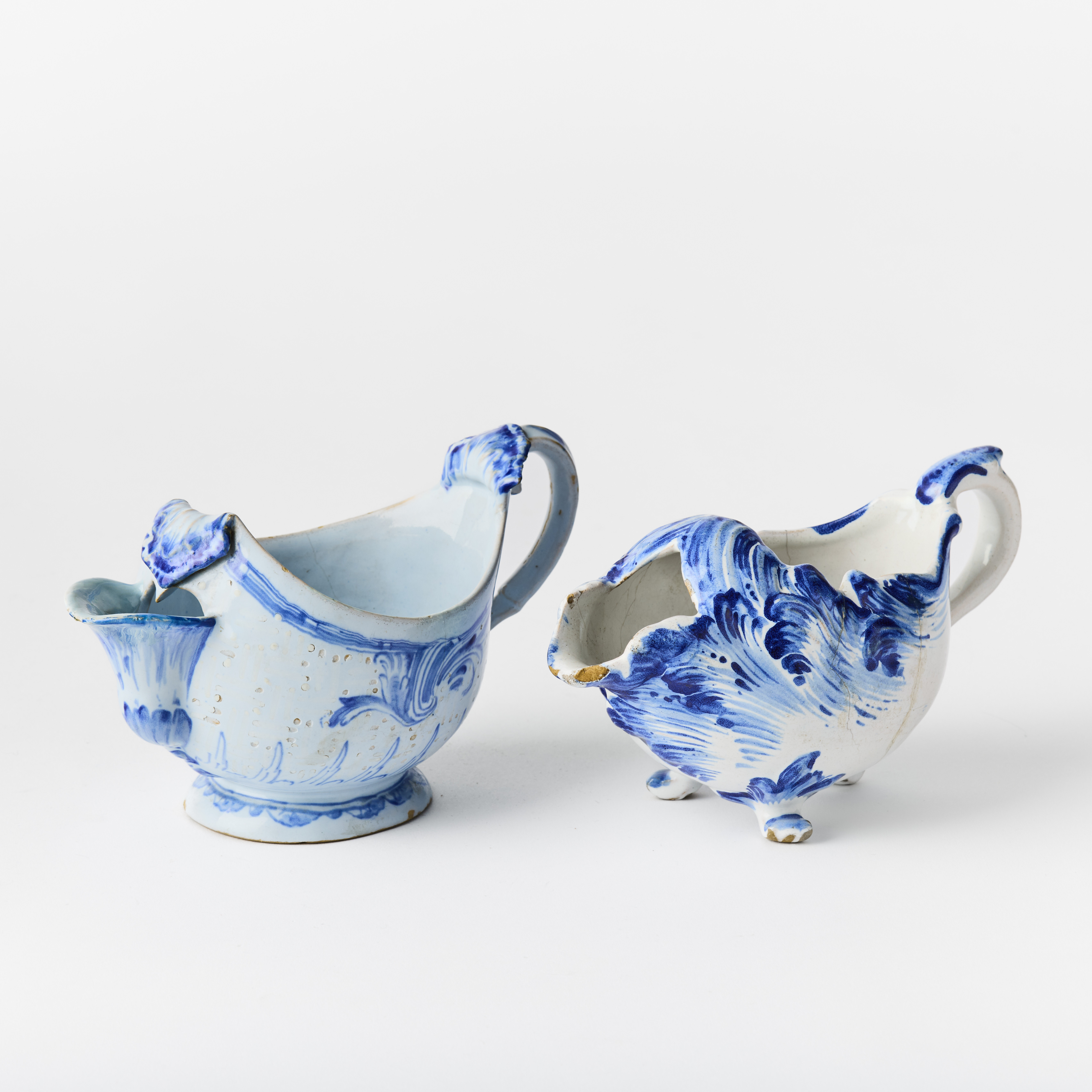 SÅSSNIPA, GRÄDDSNÄCKA, fajans, 1700-tal, rokoko, den ena med dekor av ”Rehnska mönstret” i underglasyrblått samt bianco sopra bianco, den andra med svepande bladformationer i blått.