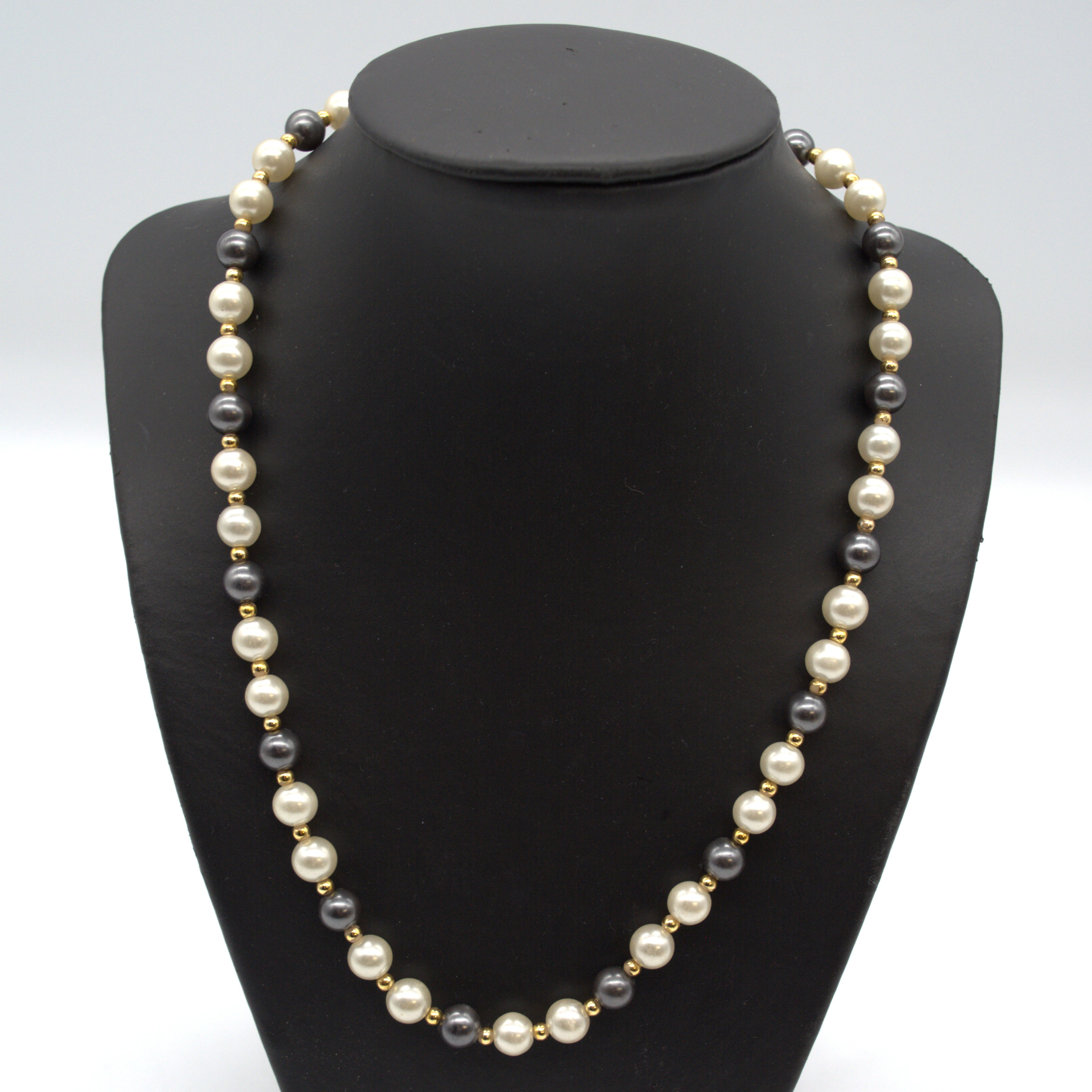 PERLENKETTE MIT IMITATIONSPERLEN,SCHWARZ, WEISS, VERGOLDETE TRENNSTÜCKE, UM 1950, CA. 50 CM.