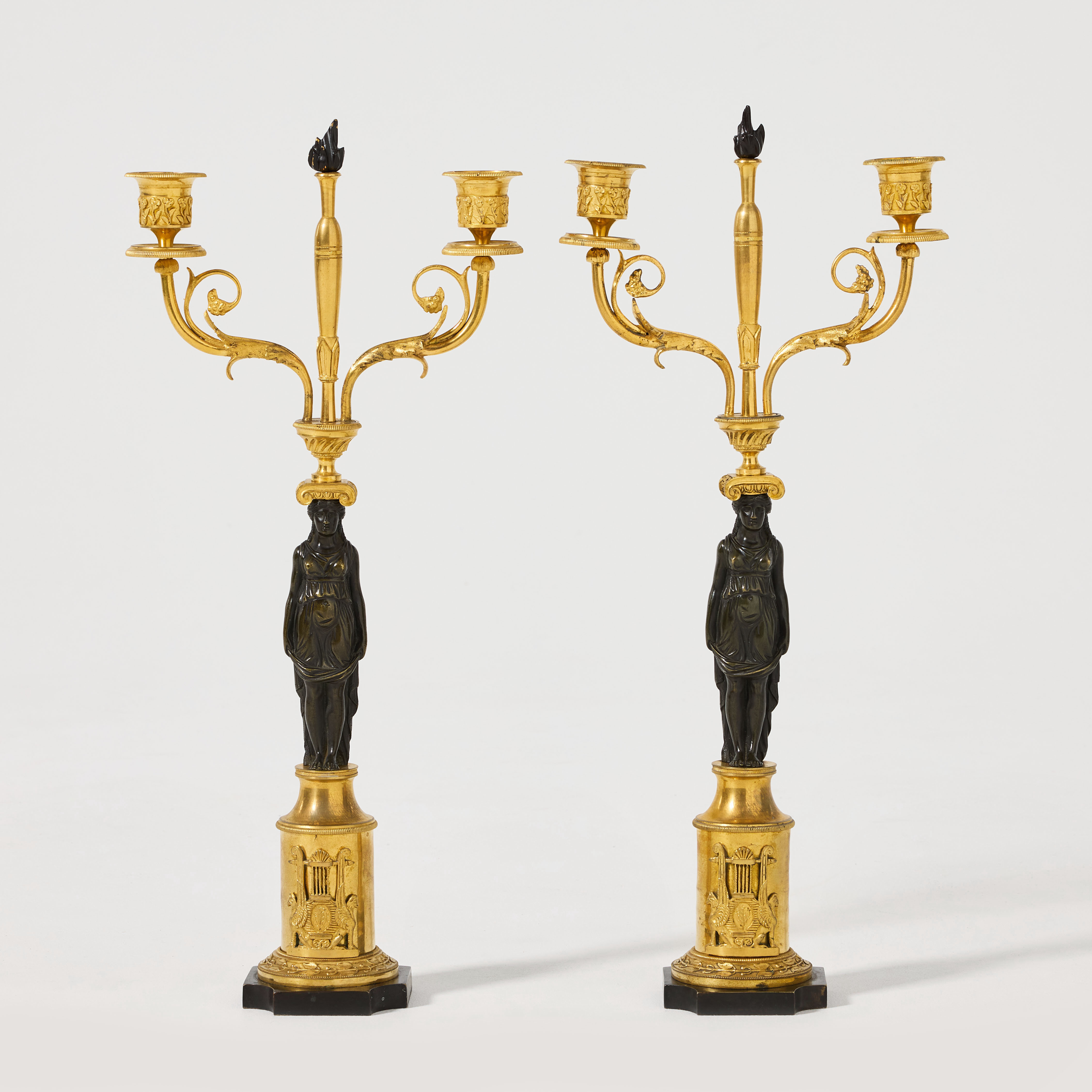 KANDELABRAR, ett par, empire, 1800-talets första kvartal, för vardera två ljus, brännförgylld och mörkpatinerad brons.